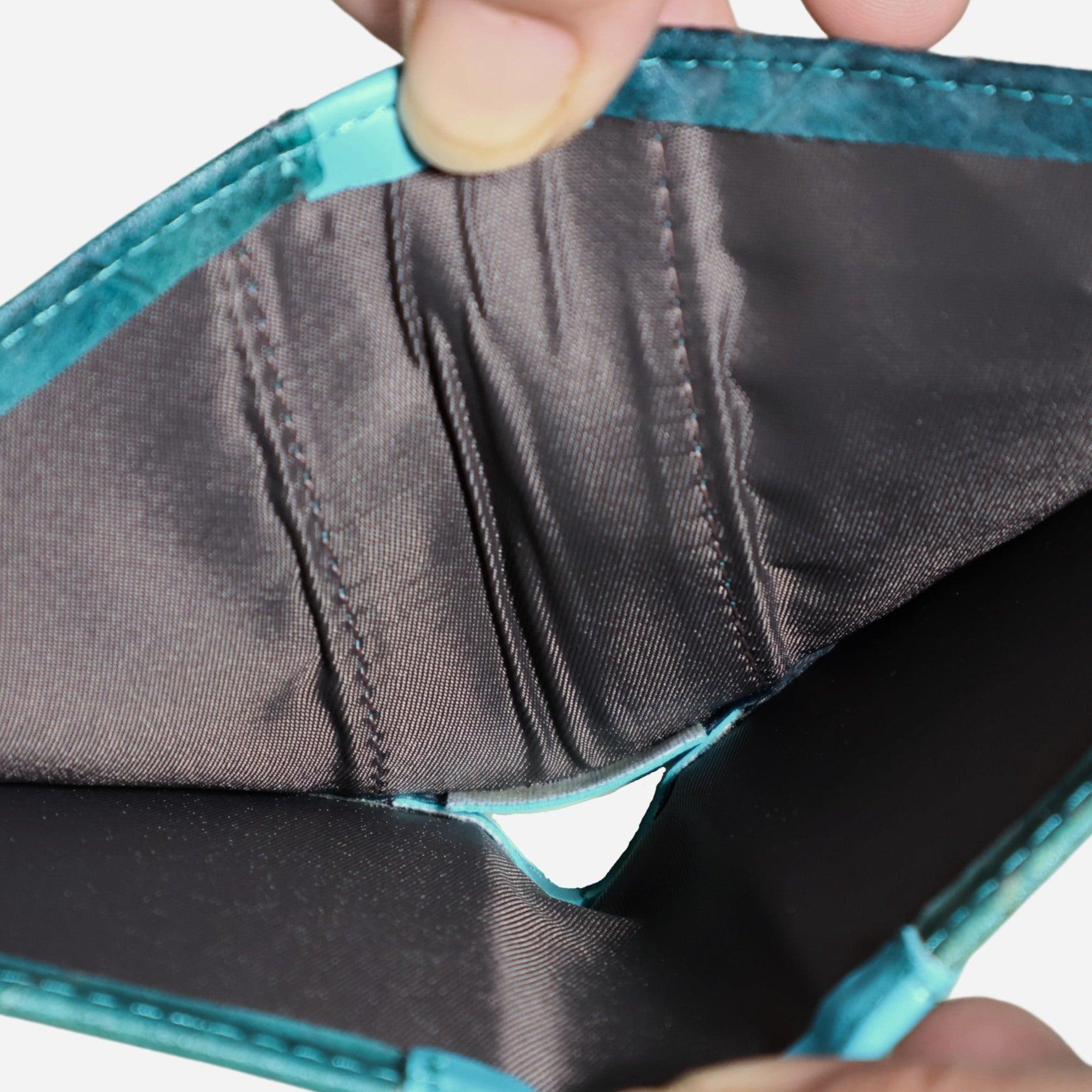Interior of turquoise bifold card wallet by Thamon, featuring microfiber lining and card slots