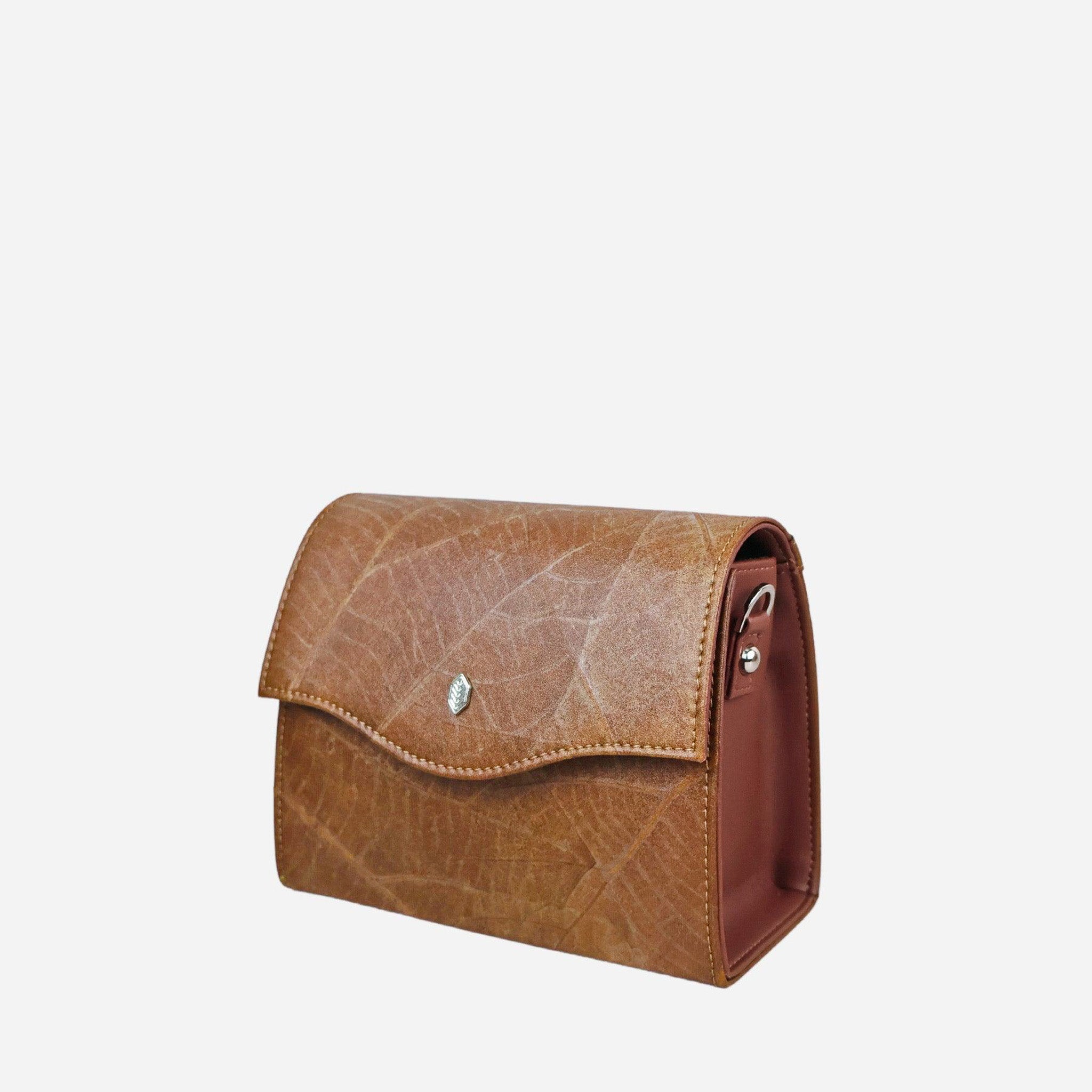 Side view of the Thamon Spice Brown Leaves Box Bag, crafted from genuine leaf leather showcasing the intricate vein patterns of leaves, with a smooth brown flap closure and the Thamon silver logo, against a clean background.