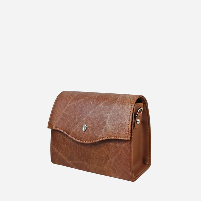 Side view of the Thamon Spice Brown Leaves Box Bag, crafted from genuine leaf leather showcasing the intricate vein patterns of leaves, with a smooth brown flap closure and the Thamon silver logo, against a clean background.