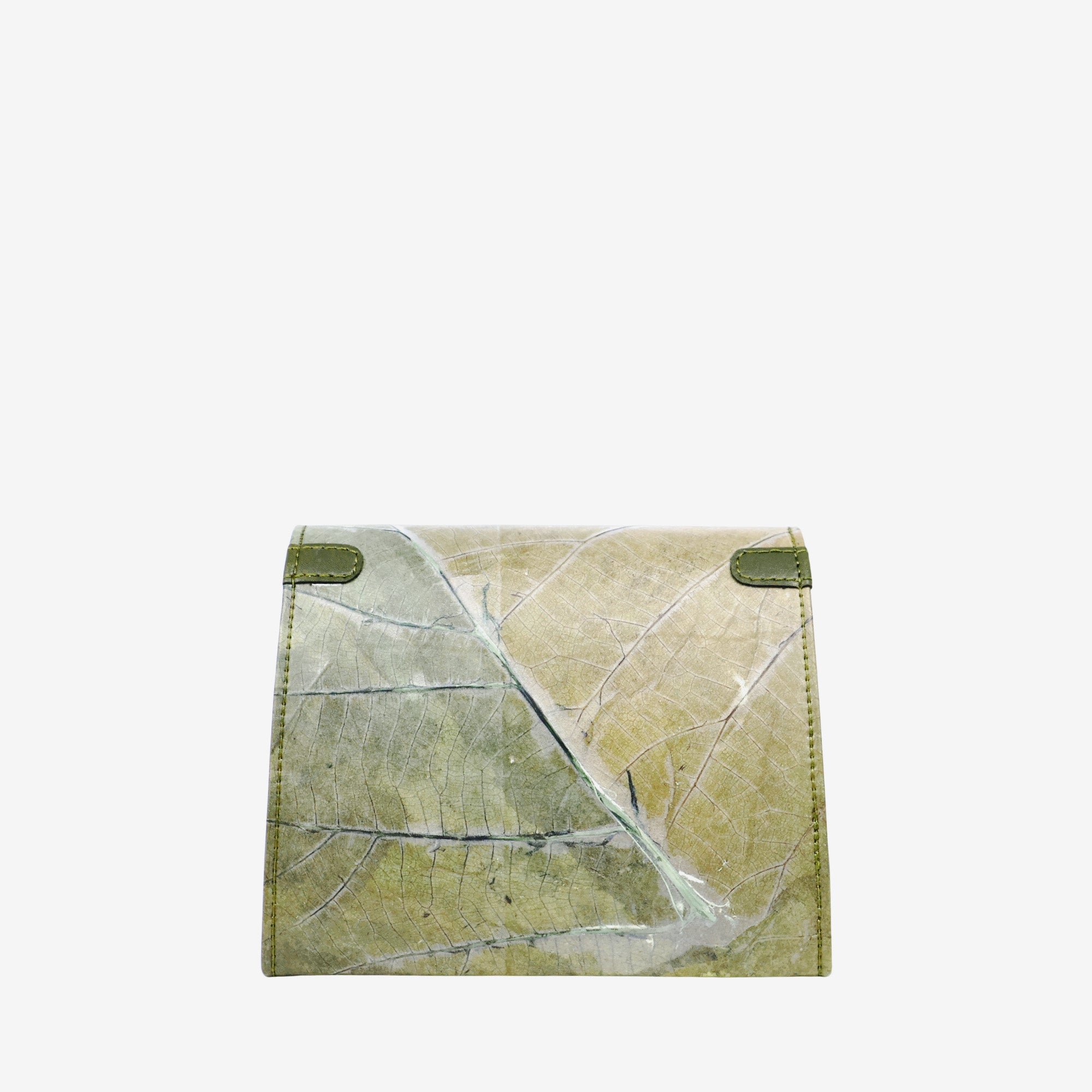 A small, green wallet made from genuine leaf leather. The back of the wallet features a distinct leaf pattern with a vein-like texture in shades of green and brown. A small, shiny blue circular detail is visible on the center of the back side. The edges of the wallet are lined with a dark green leather trim and matching green stitching. The background is a solid, light gray.