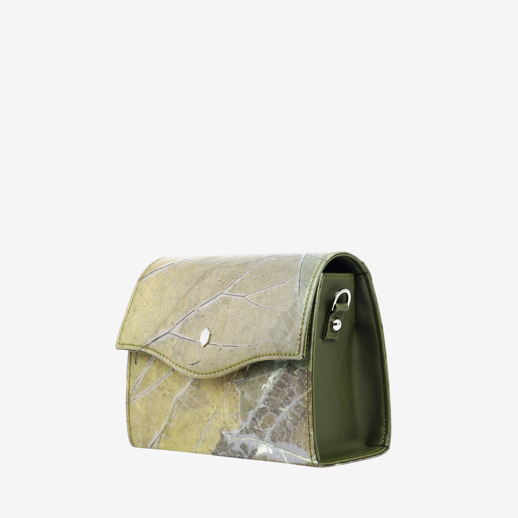 A green purse made from genuine leaf leather. The front of the purse features a visible leaf pattern with veins and a marble-like texture in shades of green, brown, and off-white. The rest of the purse is solid green. The purse has a front flap with two shiny, small, blue circular details. The side of the purse is solid green with a metal ring for a strap. The background is a solid, light gray.