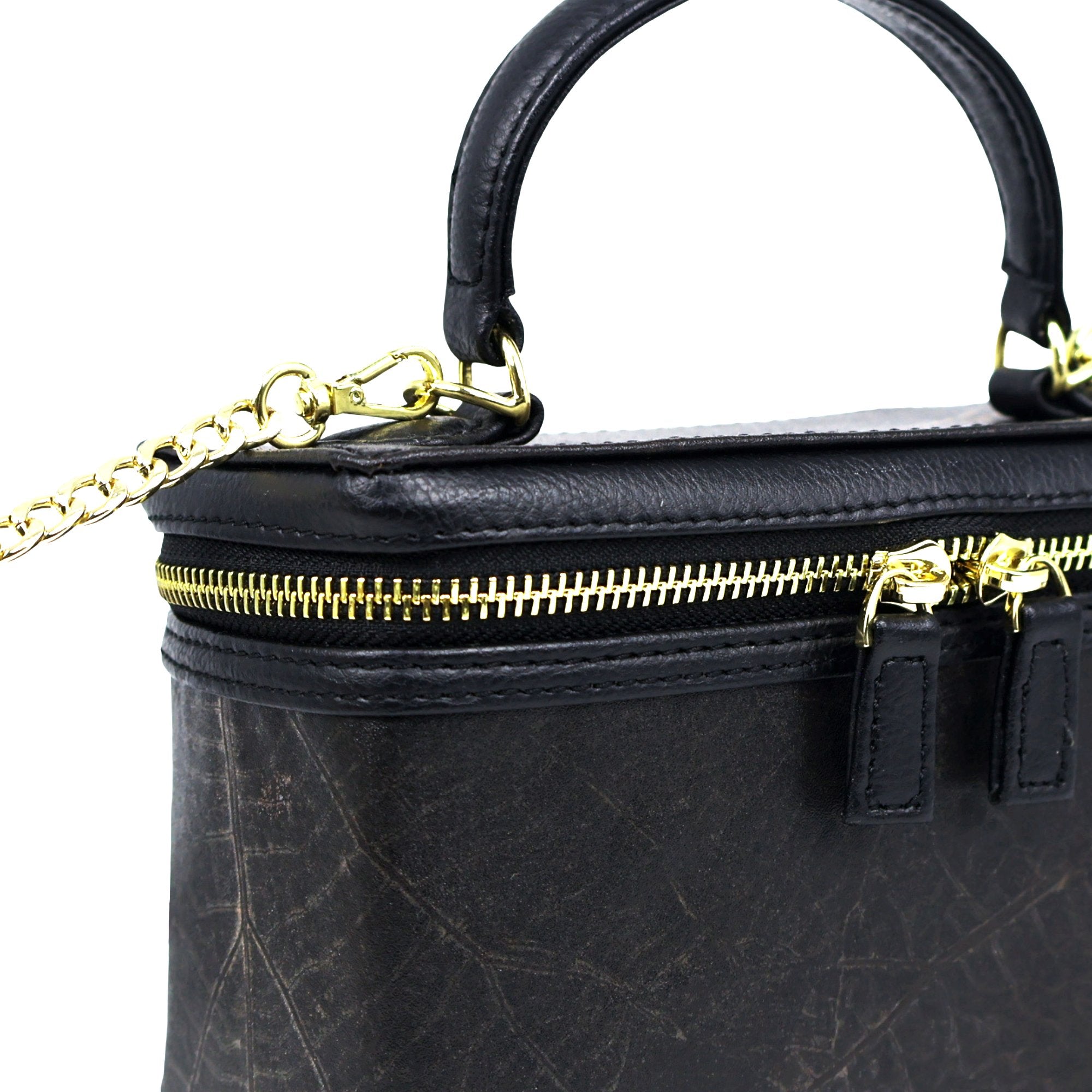 Close-up detail of Thamon Vanity Crossbody Bag in black Leaftex with gold hardware.