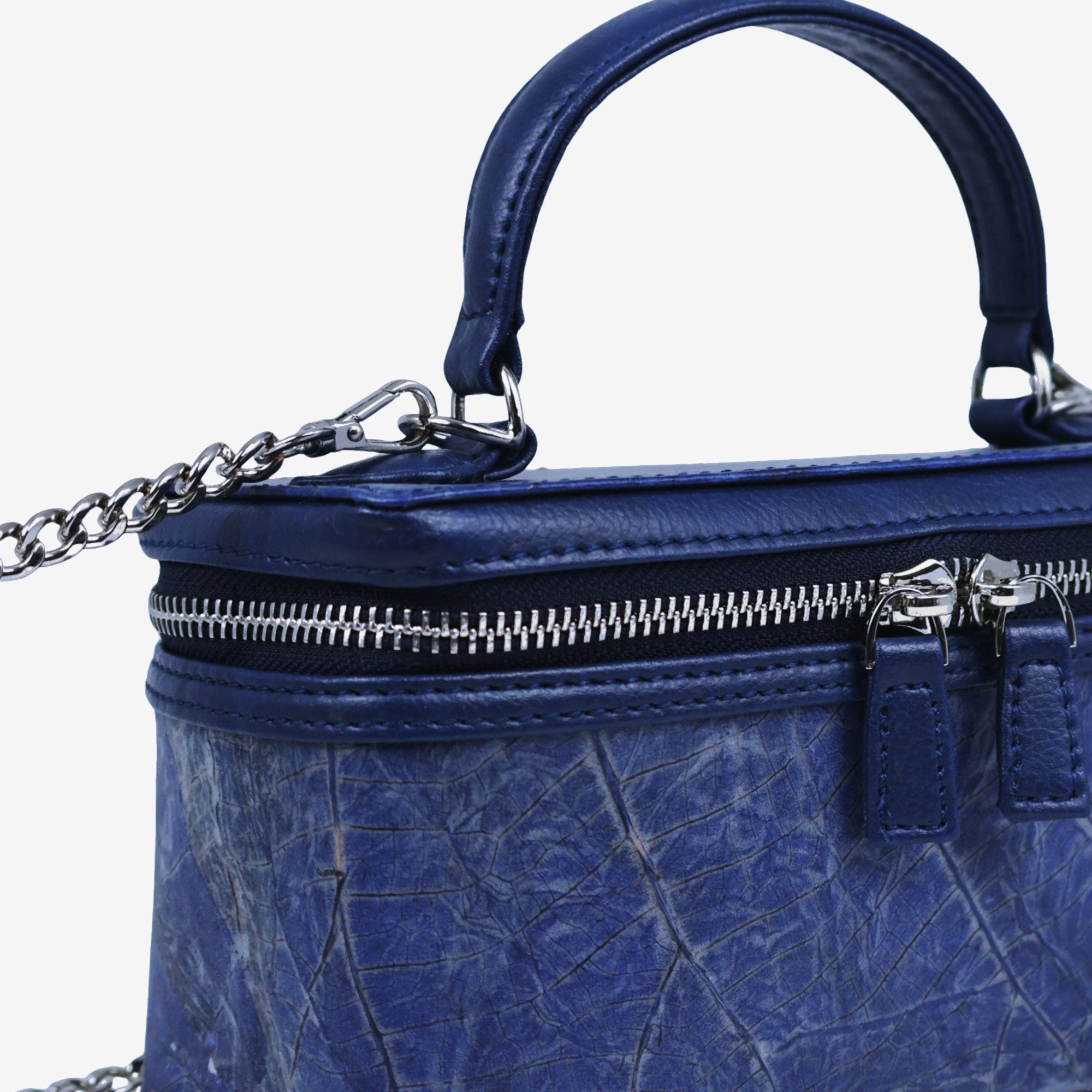 Close-up detail of Thamon Vanity Crossbody Bag in sapphire Leaftex with silver hardware.