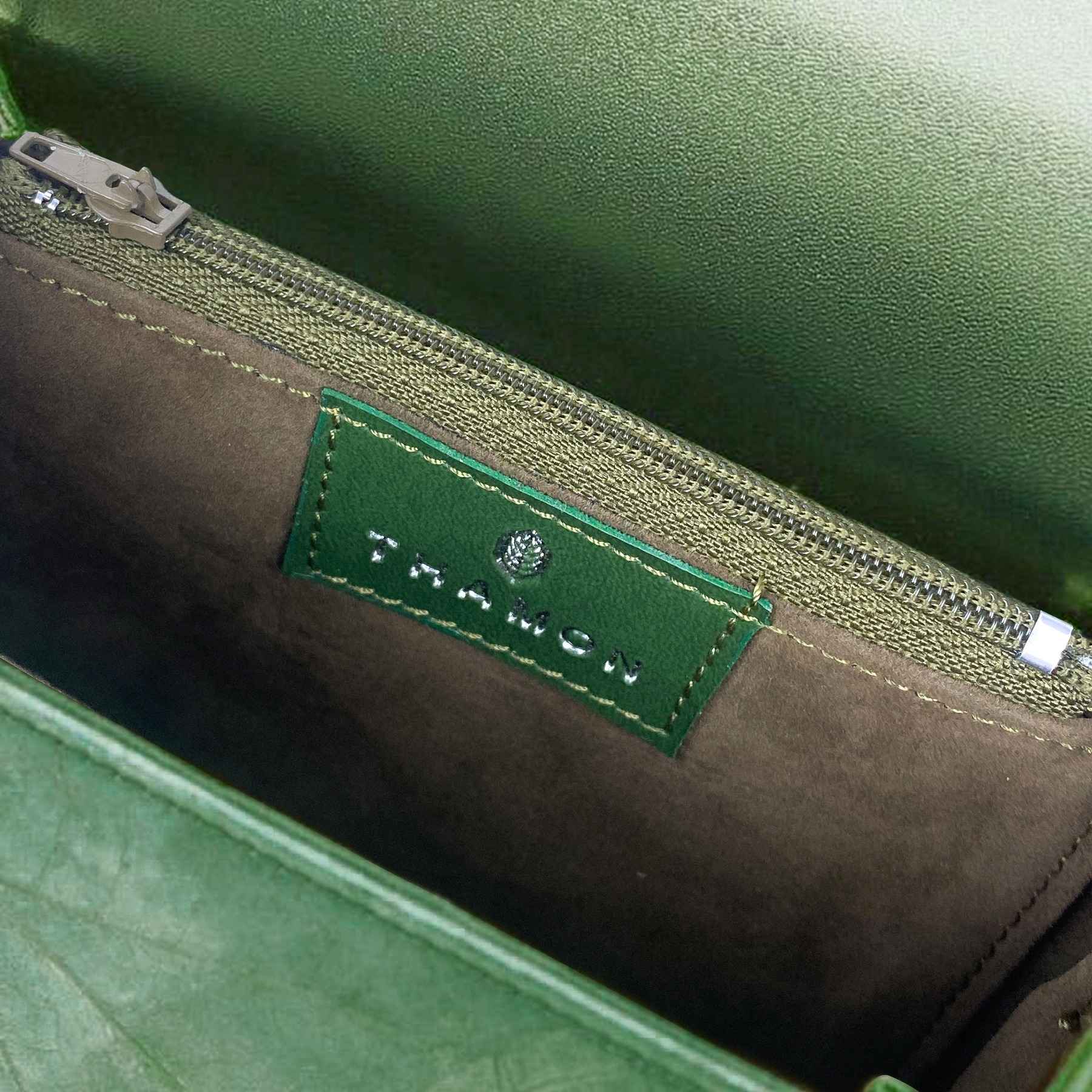 Interior detail of Box crossbody bag in Forest Green with THAMON logo label