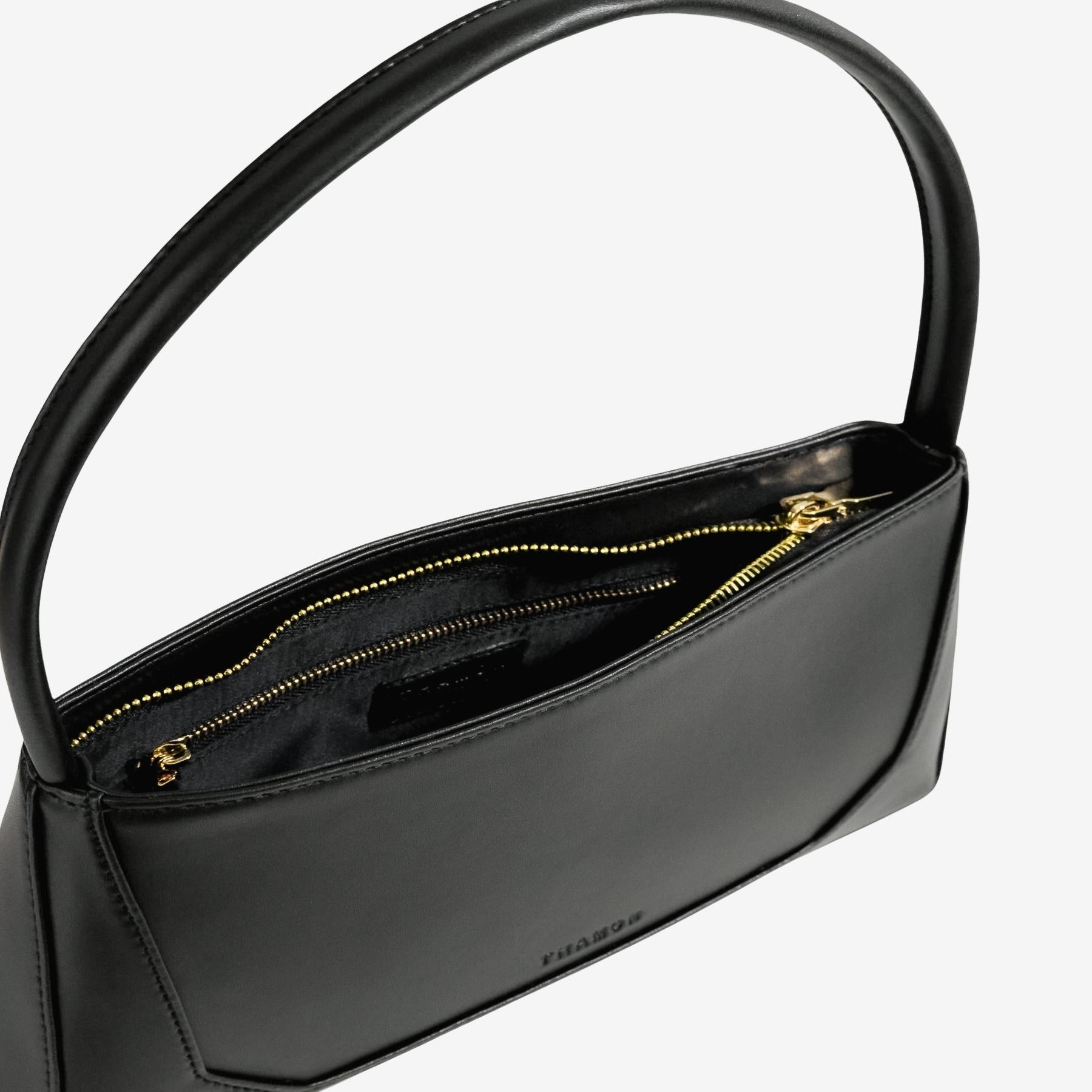 Interior view of black IVES bag showing inner compartments designed for daily essentials