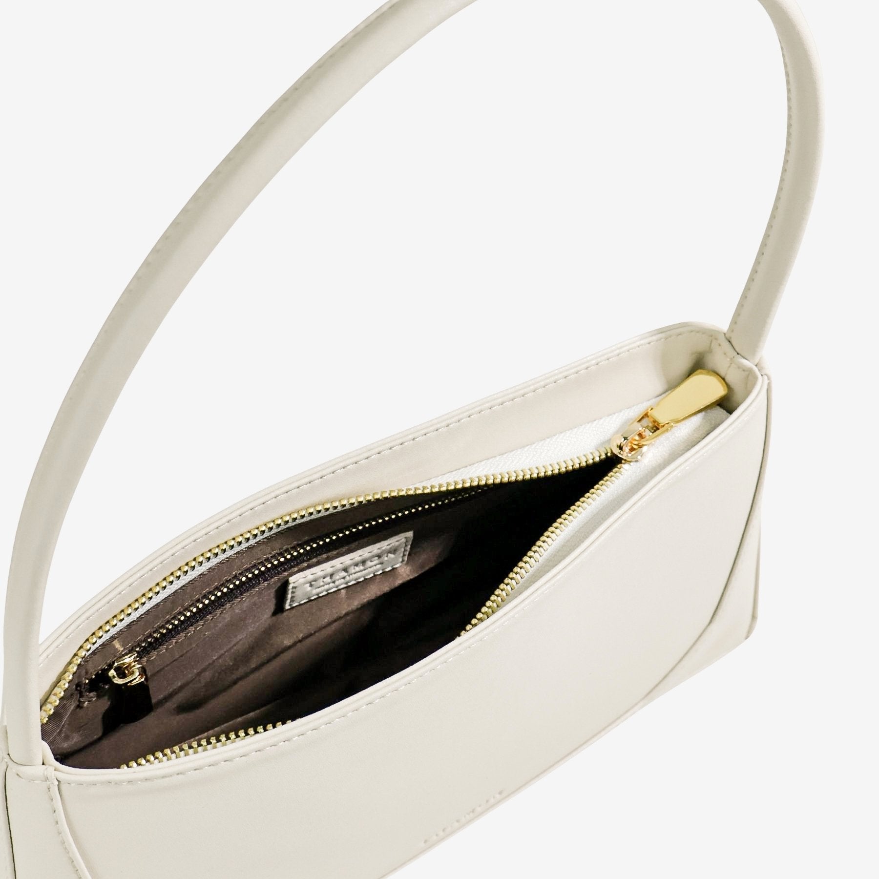 Interior view of ivory IVES bag showcasing inner pocket detail and embossed branding