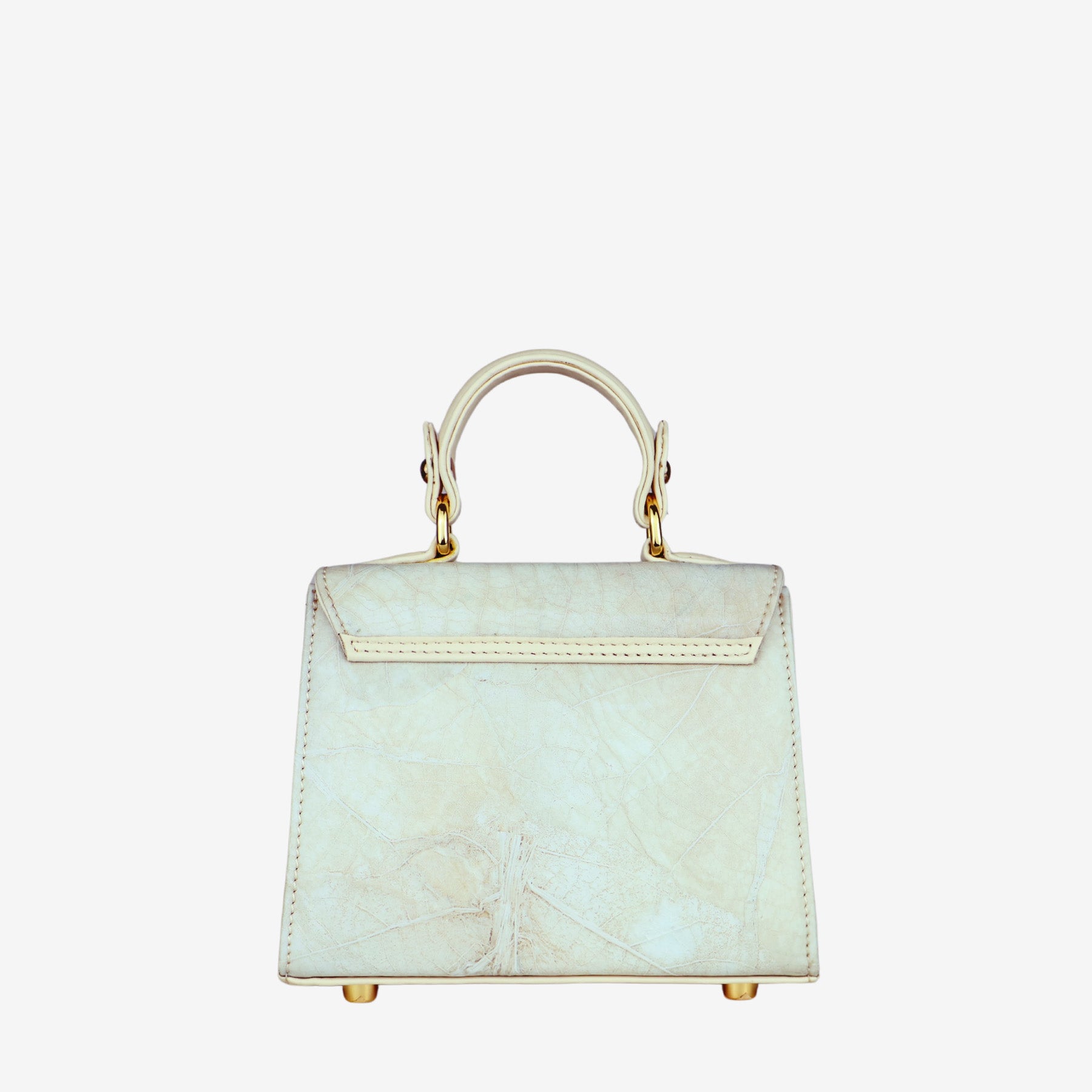 Back view of a cream-colored women's handbag with a subtle leaf-like texture. The bag features a single top handle connected by gold-tone hardware. The back of the bag has a smooth flap closure with stitched detailing and the same textured material on the main body. The base is equipped with four gold-tone metal feet.