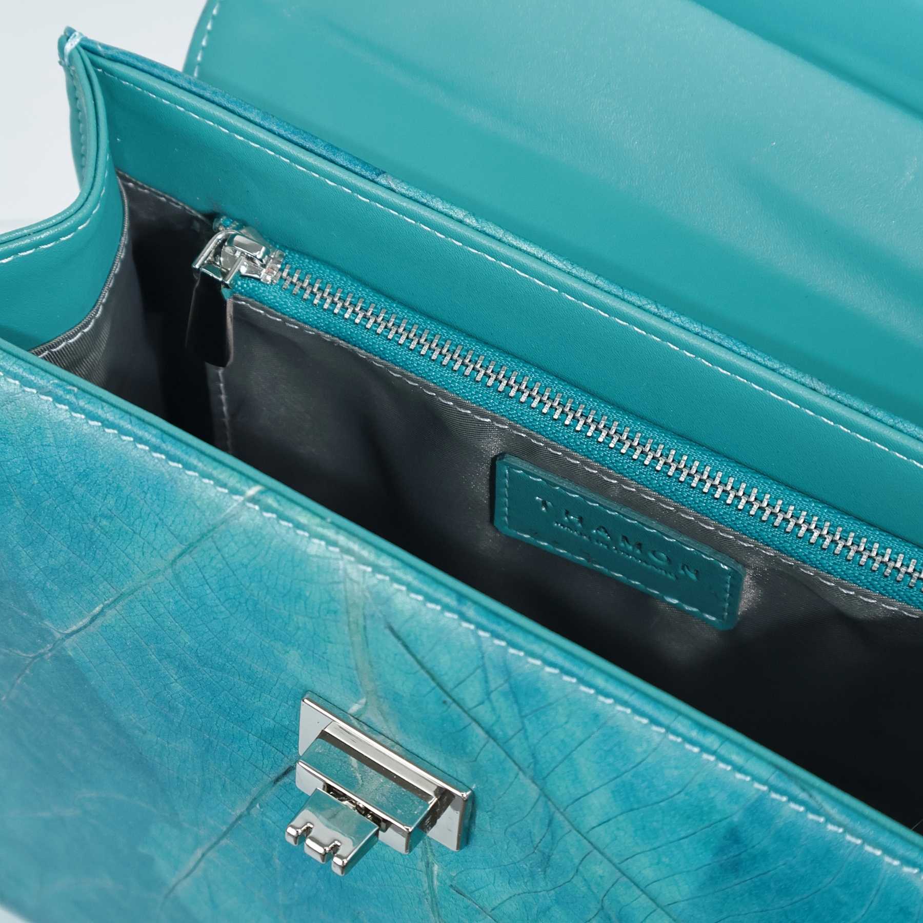 Interior of the Kylie handbag in turquoise Leaftex showing the zip pocket, lining, and silver-tone hardware.