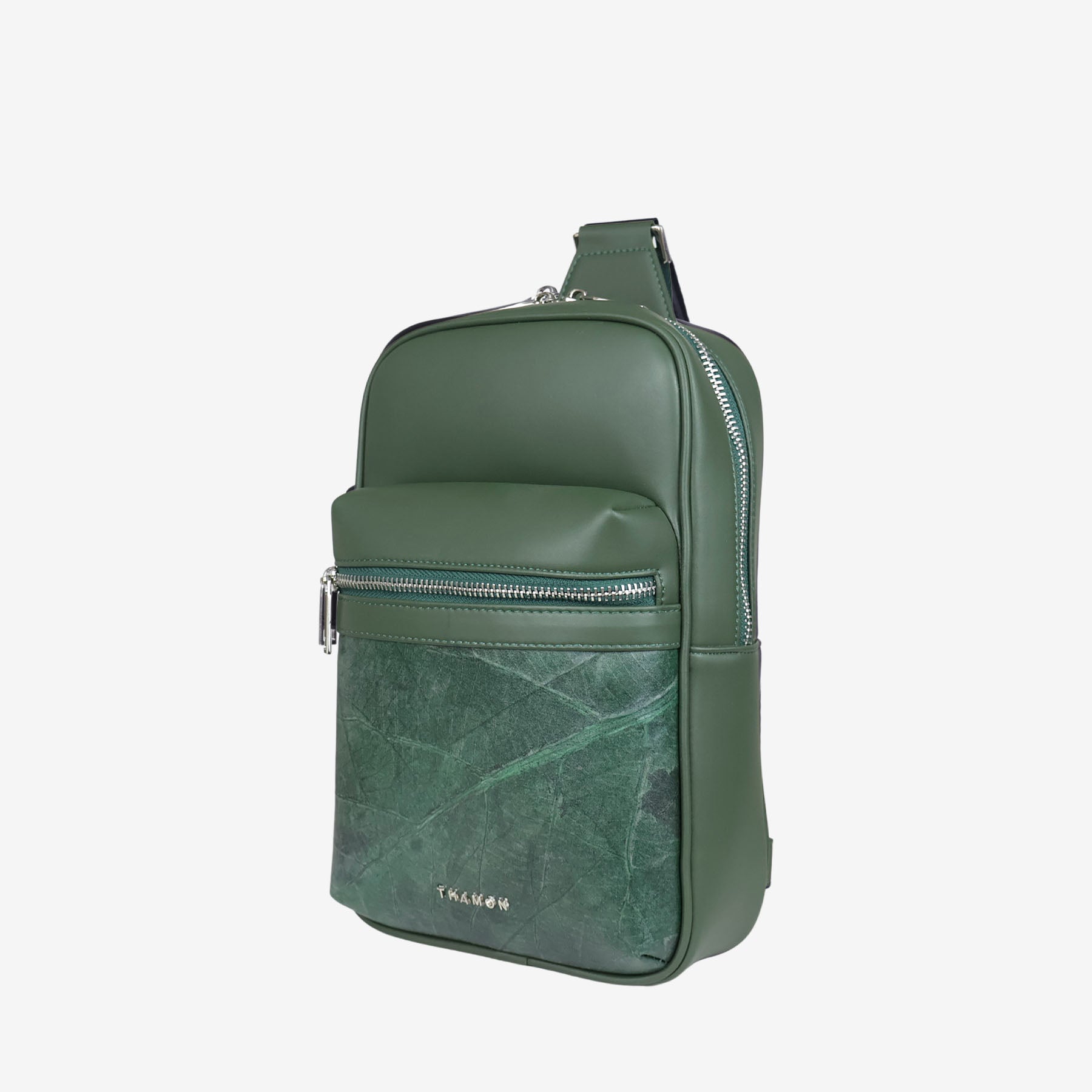 Side view of Nomad sling bag in forest green with front zip pocket and bold natural leaf pattern panel