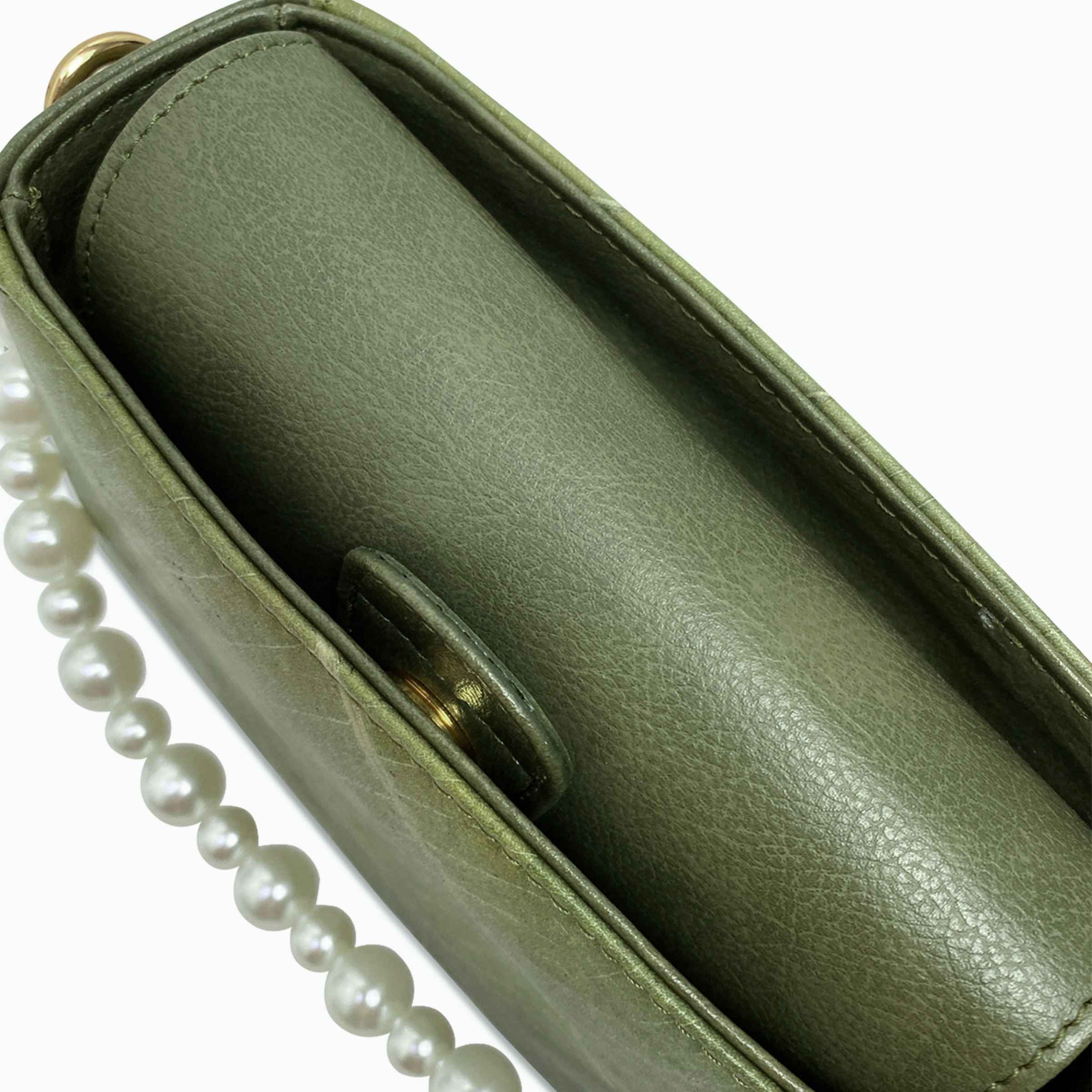 Top view of Pearl bag in olive green leaf leather with magnetic flap and pearl strap