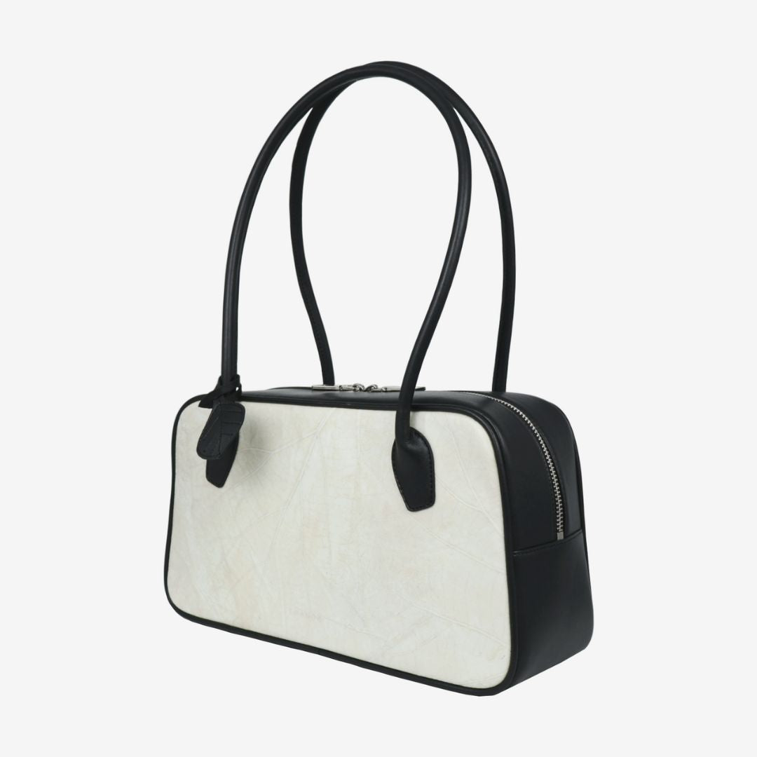 Side profile of Thamon Boston Shoulder Bag in ivory white with black handles.