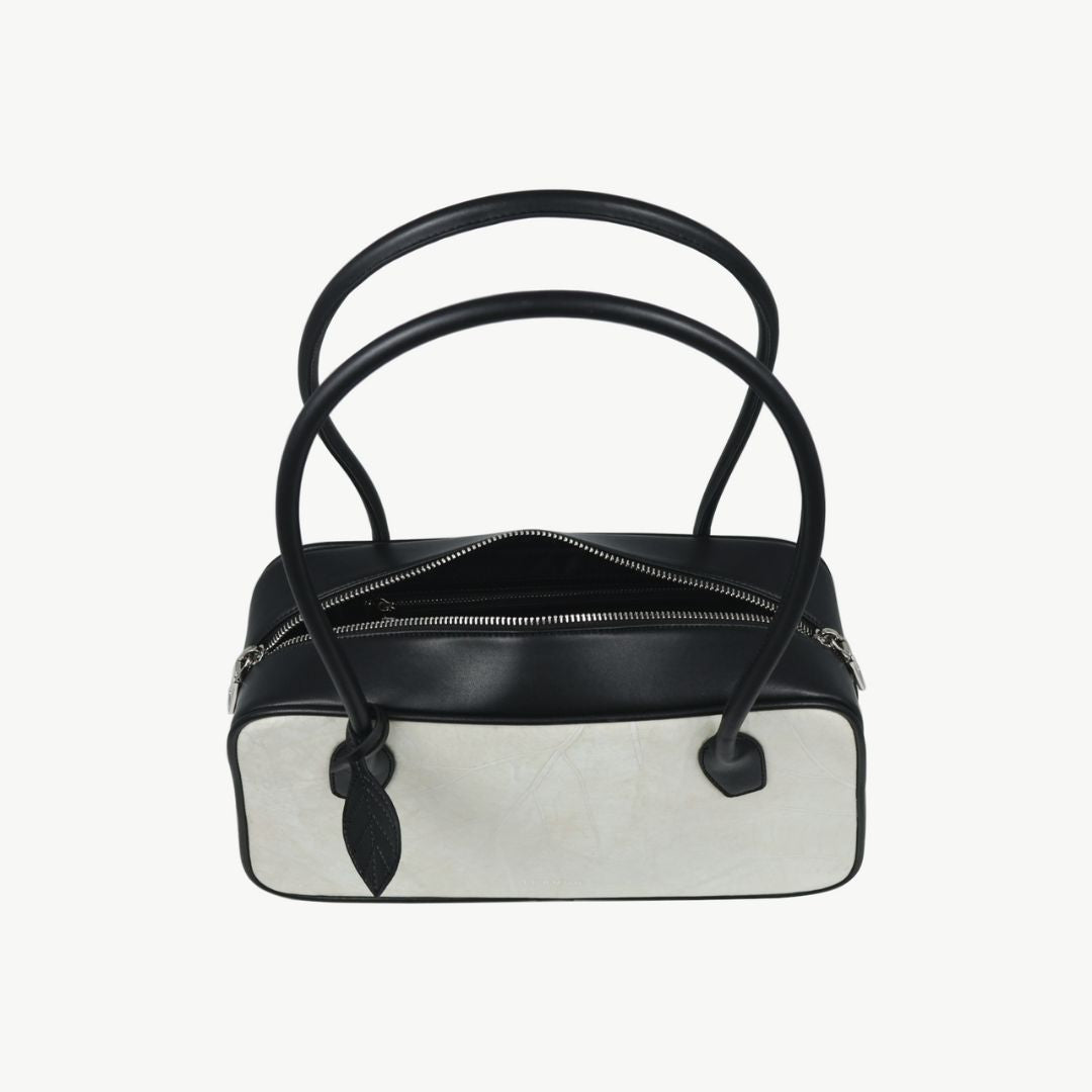 Top view of Thamon Boston Shoulder Bag in ivory white and black with zipper closure.