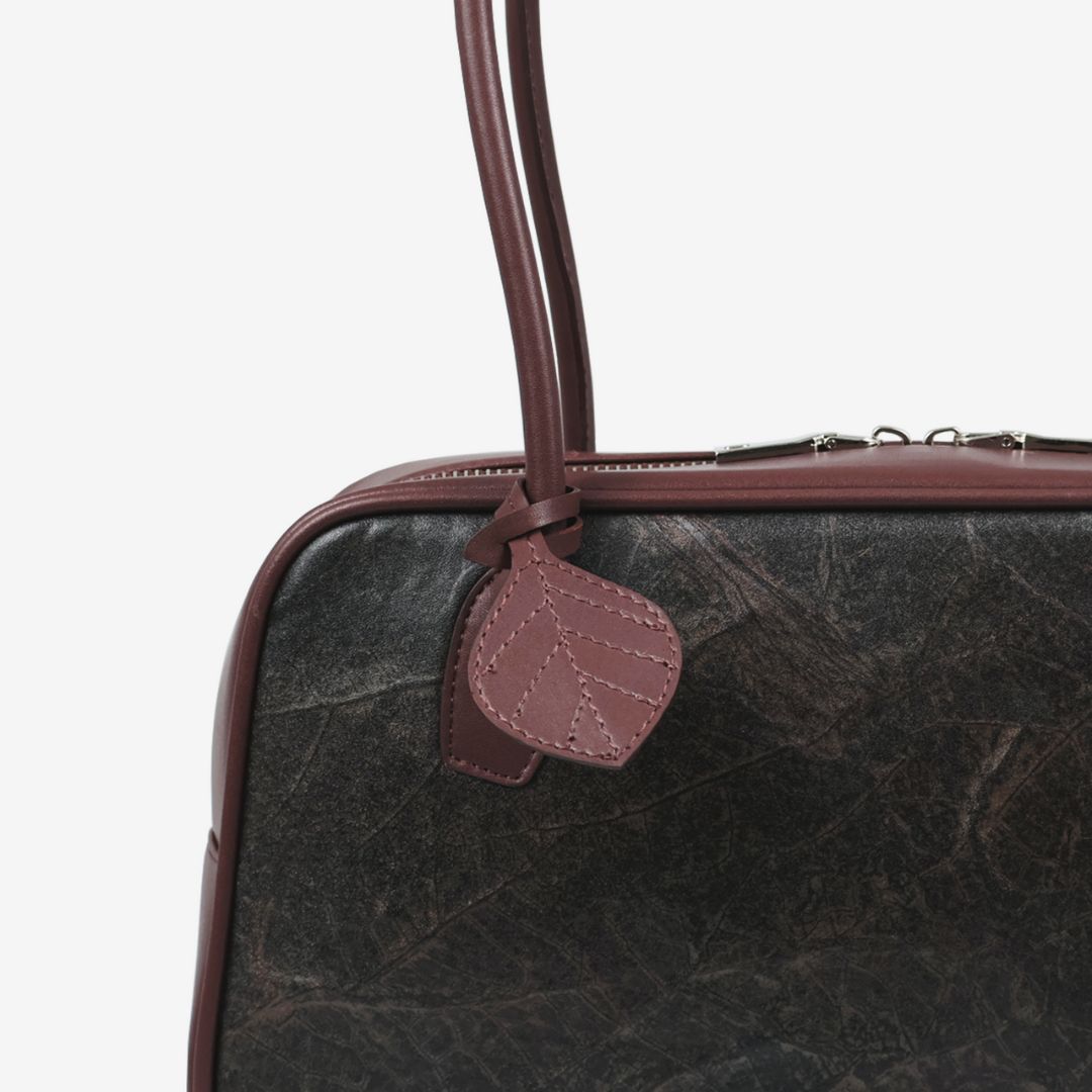 Close-up detail of Thamon Boston Shoulder Bag in rustic brown Leaftex vegan leather texture.
