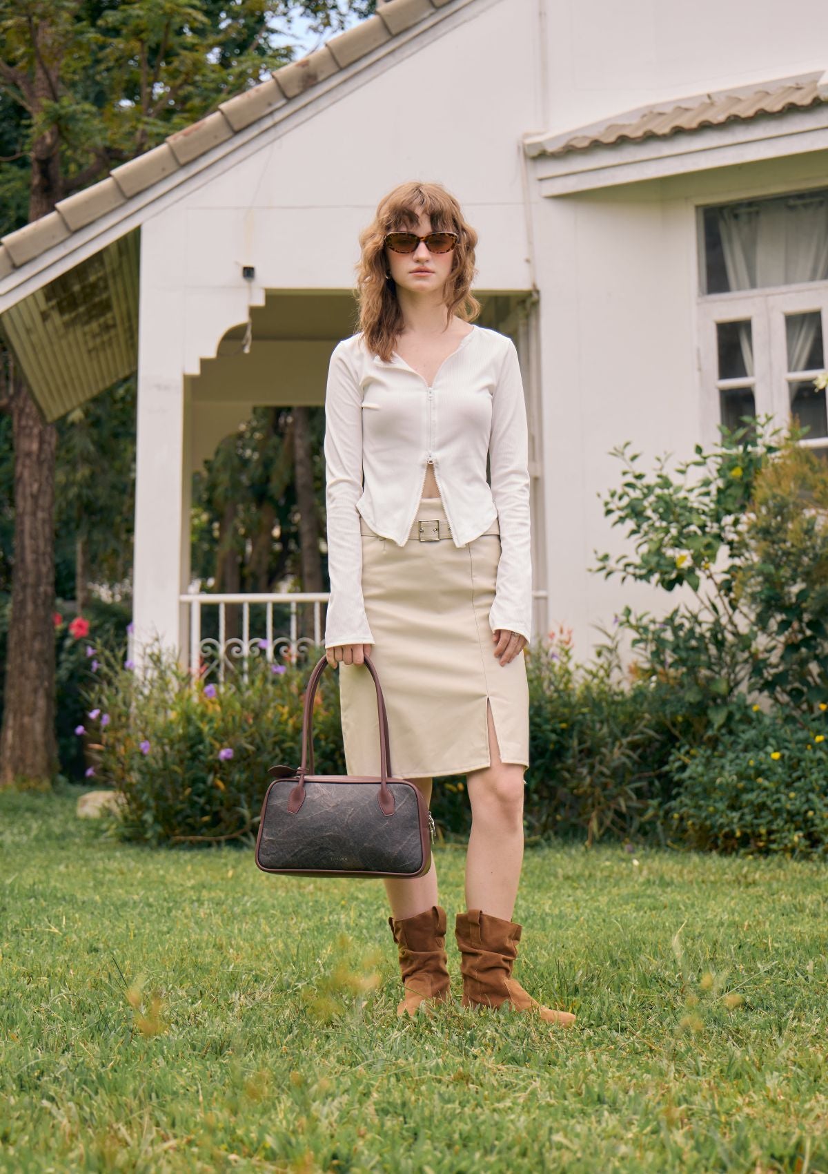 Full-body outdoor image of model carrying the Thamon Boston Bag in Rustic Brown Leaftex.