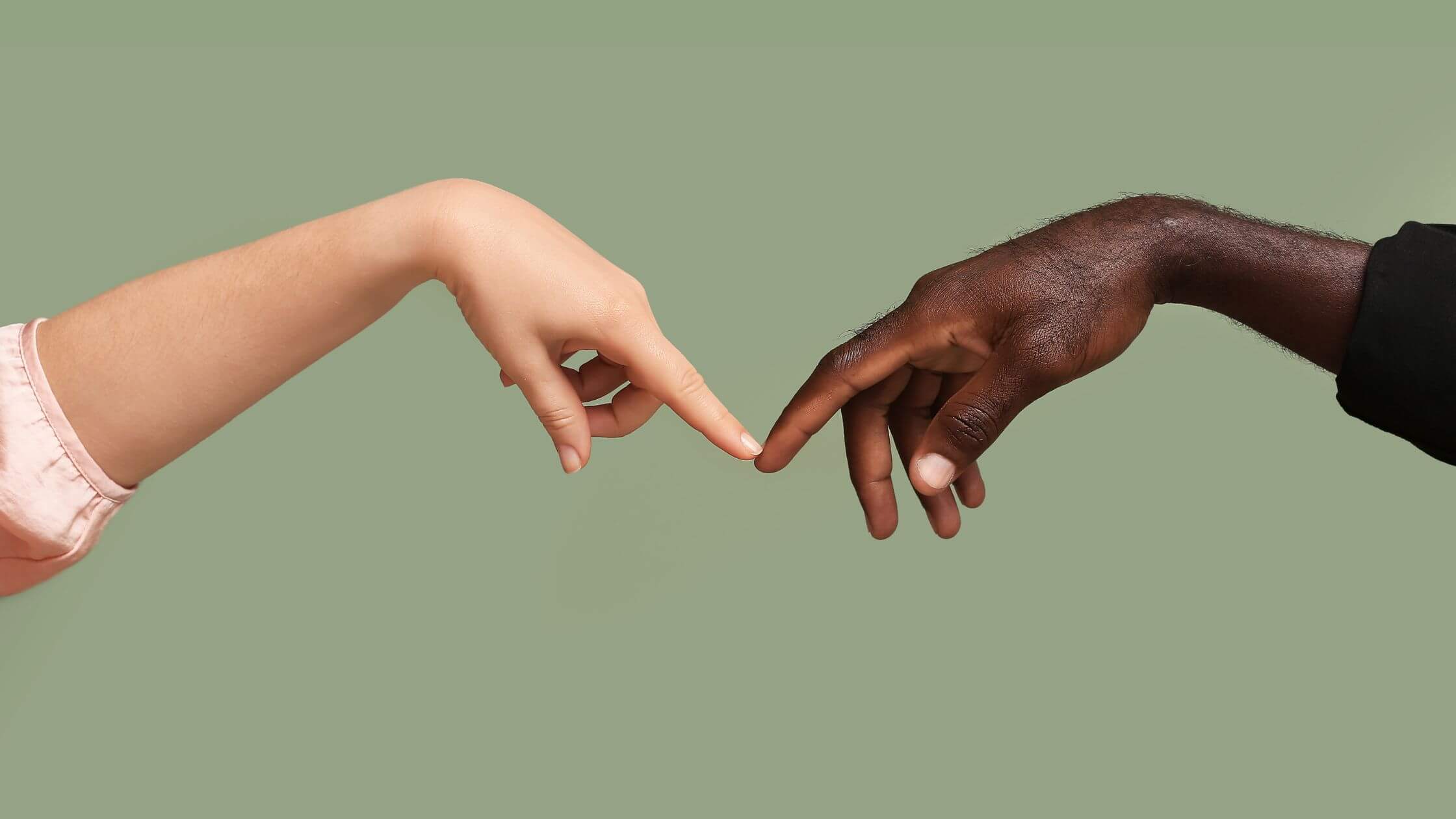 Touching fingertips of light and dark-skinned hands against a blue background symbolize unity and diversity. This image represents connection, equality, and collaboration, ideal for content on social justice, inclusion, and human relationships.
