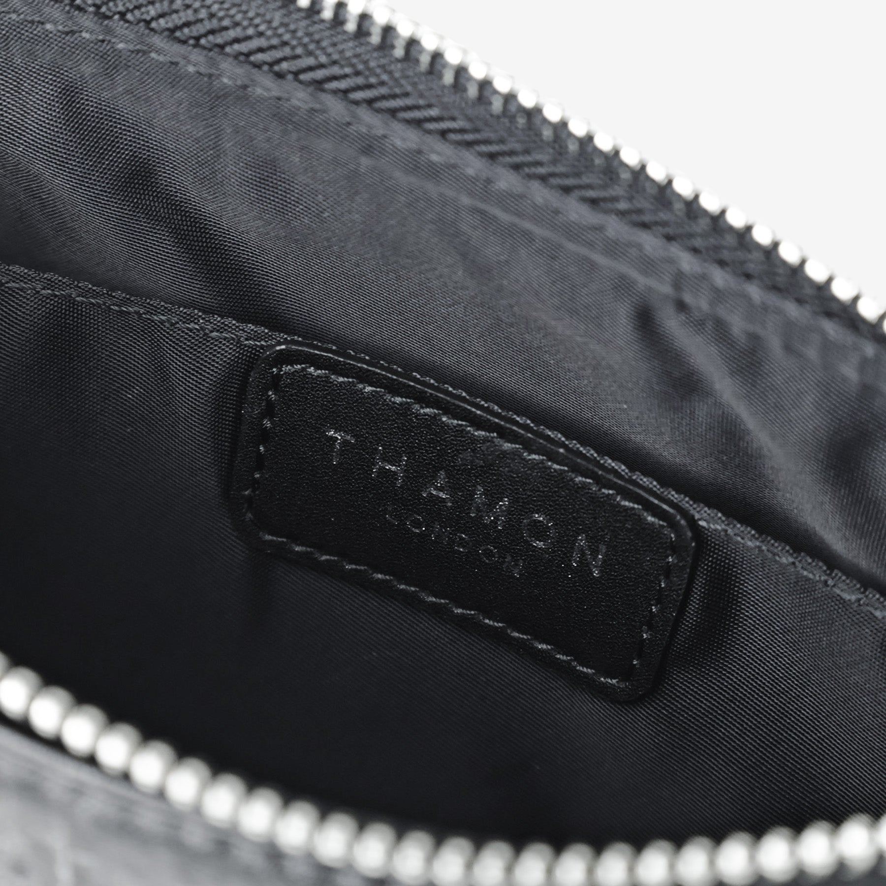 Inside detail of the Black Maki bag showing the THAMON brand label and fabric lining
