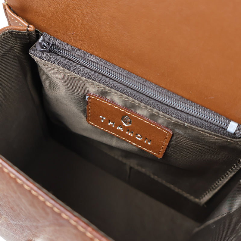 Interior view of the Thamon Spice Brown vegan Leaves Box Bag, featuring a smooth, tawny brown lining with a zippered pocket, and a leather patch embossed with the Thamon logo, highlighting the bag's practical design and luxurious feel