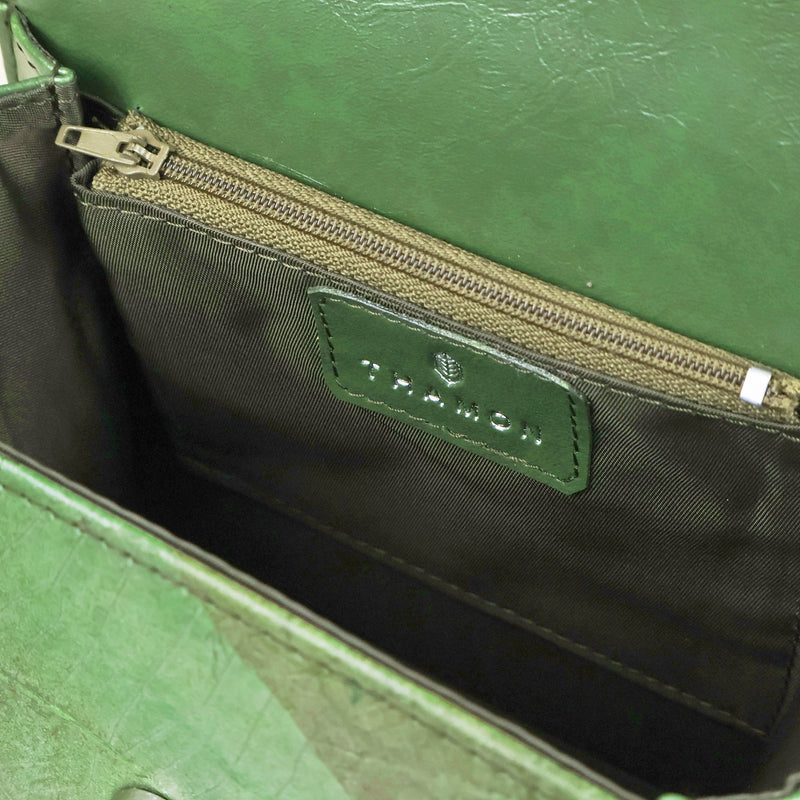Interior of the Thamon Forest Green Leaf Leather Box Bag, presenting a khaki green lining with a vegan leather logo patch above the zippered pocket, offering both style and practicality.