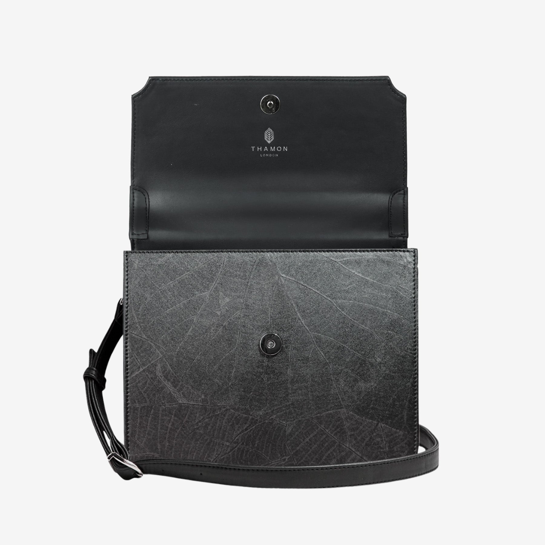 Front view of Camden crossbody bag in black Leaftex with flap open, showing magnetic closure and interior branding detail