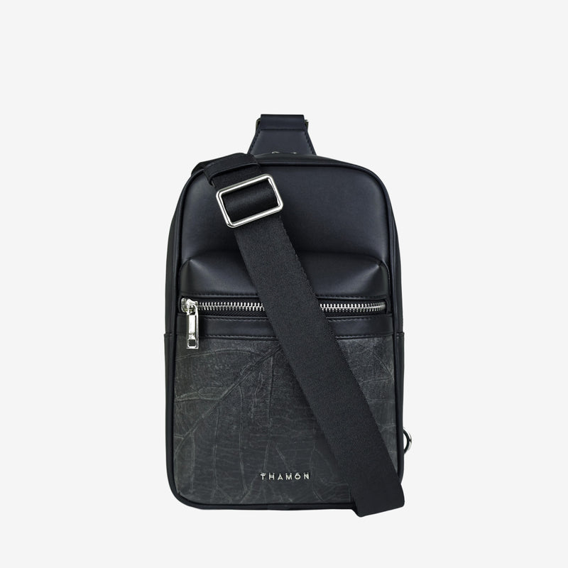 Front view of the Thamon Nomad sling bag in black, featuring a sleek design with a silver-tone zipper, an adjustable strap, and the Thamon logo embossed on the front pocket.