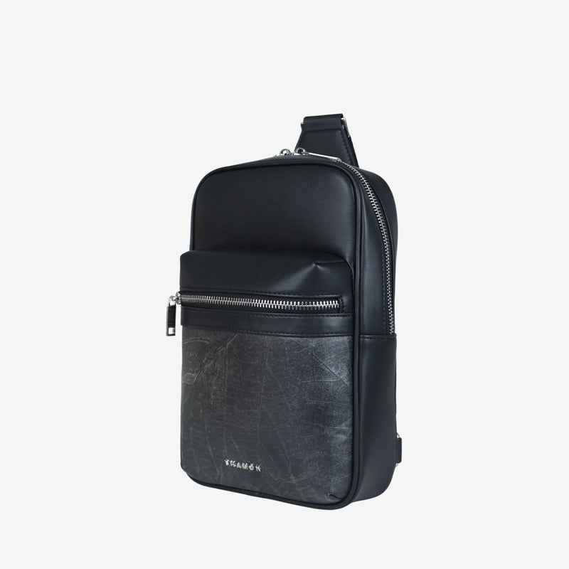 Side view of the Thamon Nomad sling bag in black, featuring a sleek design with a silver-tone zipper, an adjustable strap, and the Thamon logo embossed on the front pocket.