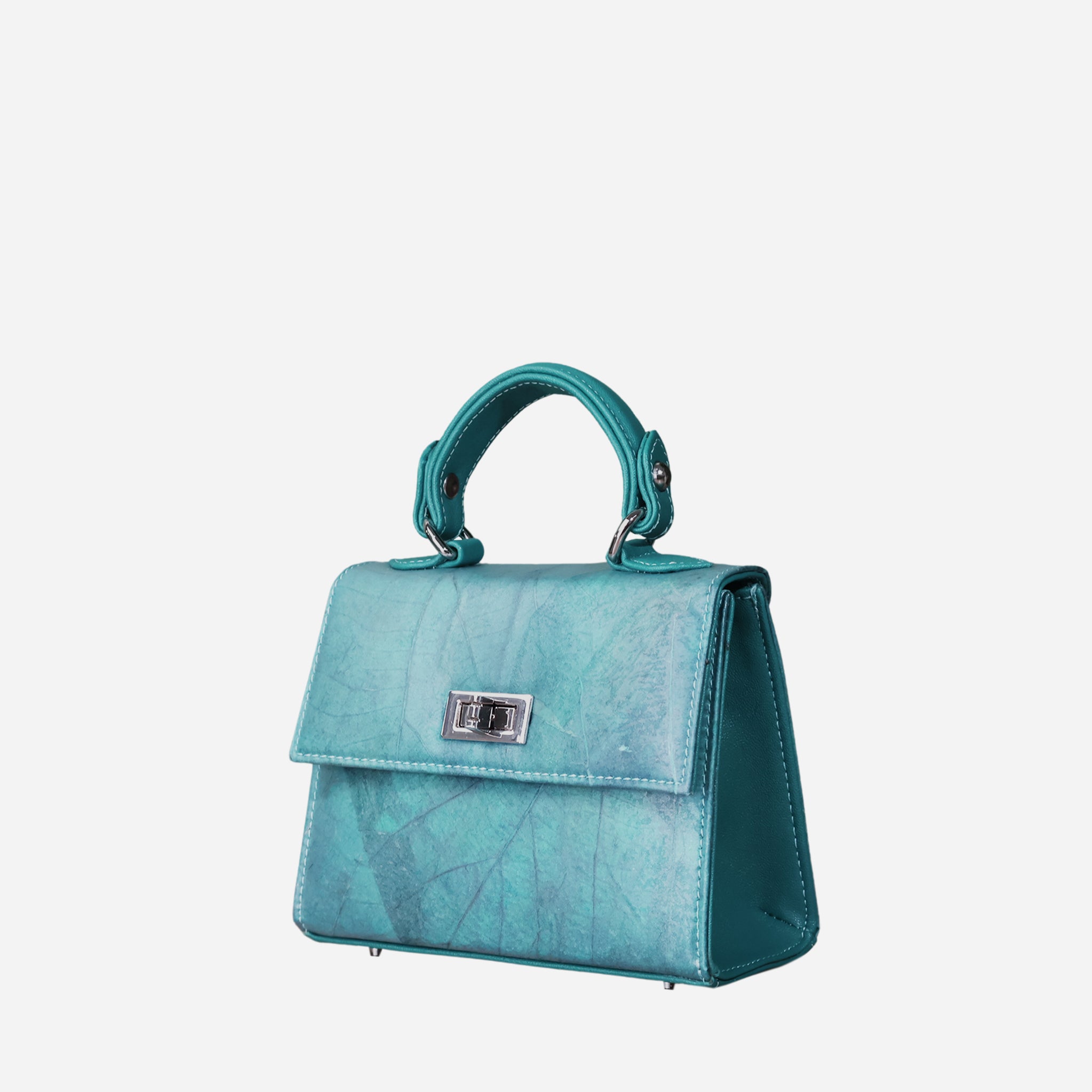 Front view of a structured, teal-colored women's handbag with a subtle leaf-like texture. The bag features a silver-tone twist-lock closure on the front flap, a single top handle, and four silver-tone metal feet on the bottom. The side panels of the bag are smooth, contrasting with the textured front and back.