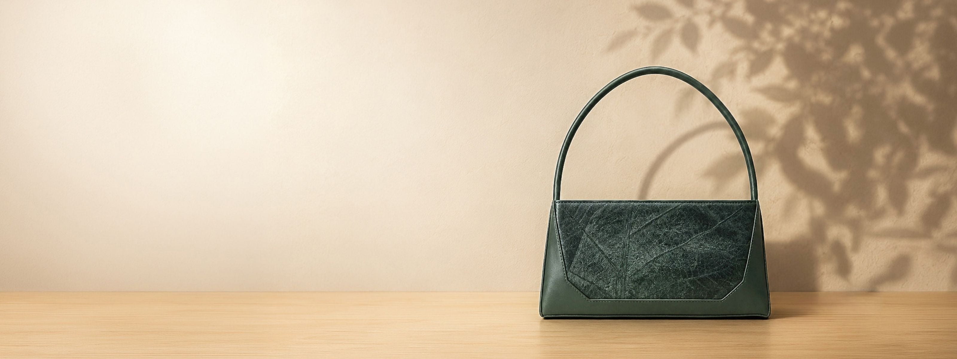 Minimal luxury product launch banner for the new Ives collection in forest green leaf leather by THAMON