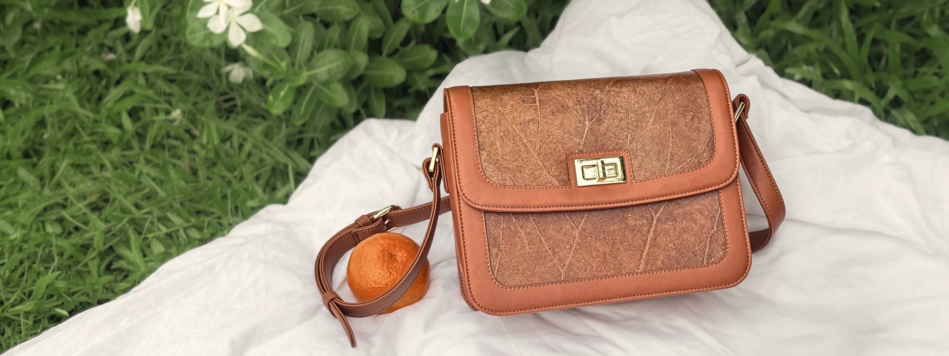 Copenhagen Bag in Caramel with Leaftex panels, styled on white linen outdoors for The Summer Bag Edit.