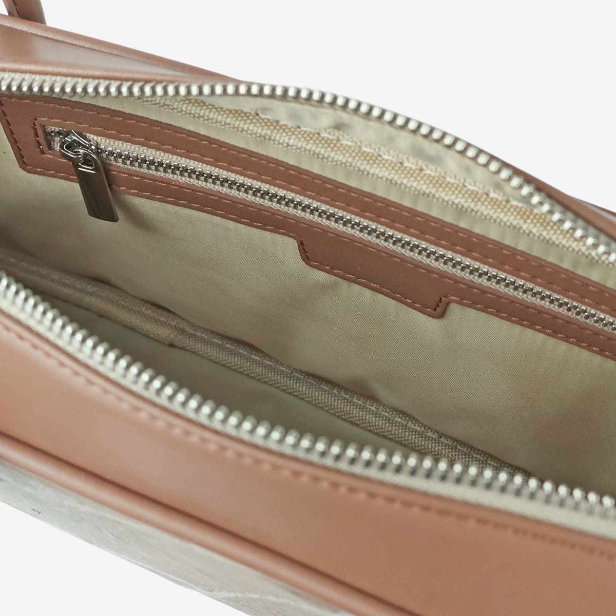 Interior of the THAMON CRAUGETTE shoulder bag in Taupe, showing light fabric lining, a zipped pocket and silver-tone zip hardware.