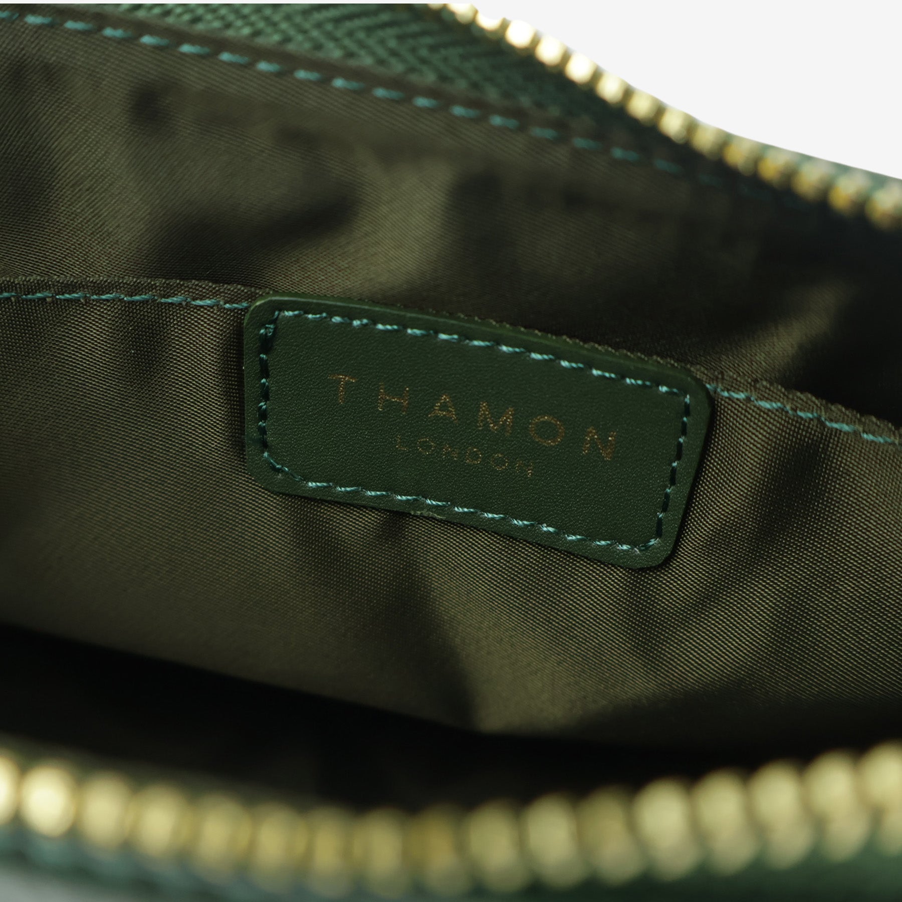 Close-up of the interior of Forest Green Maki Bag, showing the Thamon logo tag on the lining