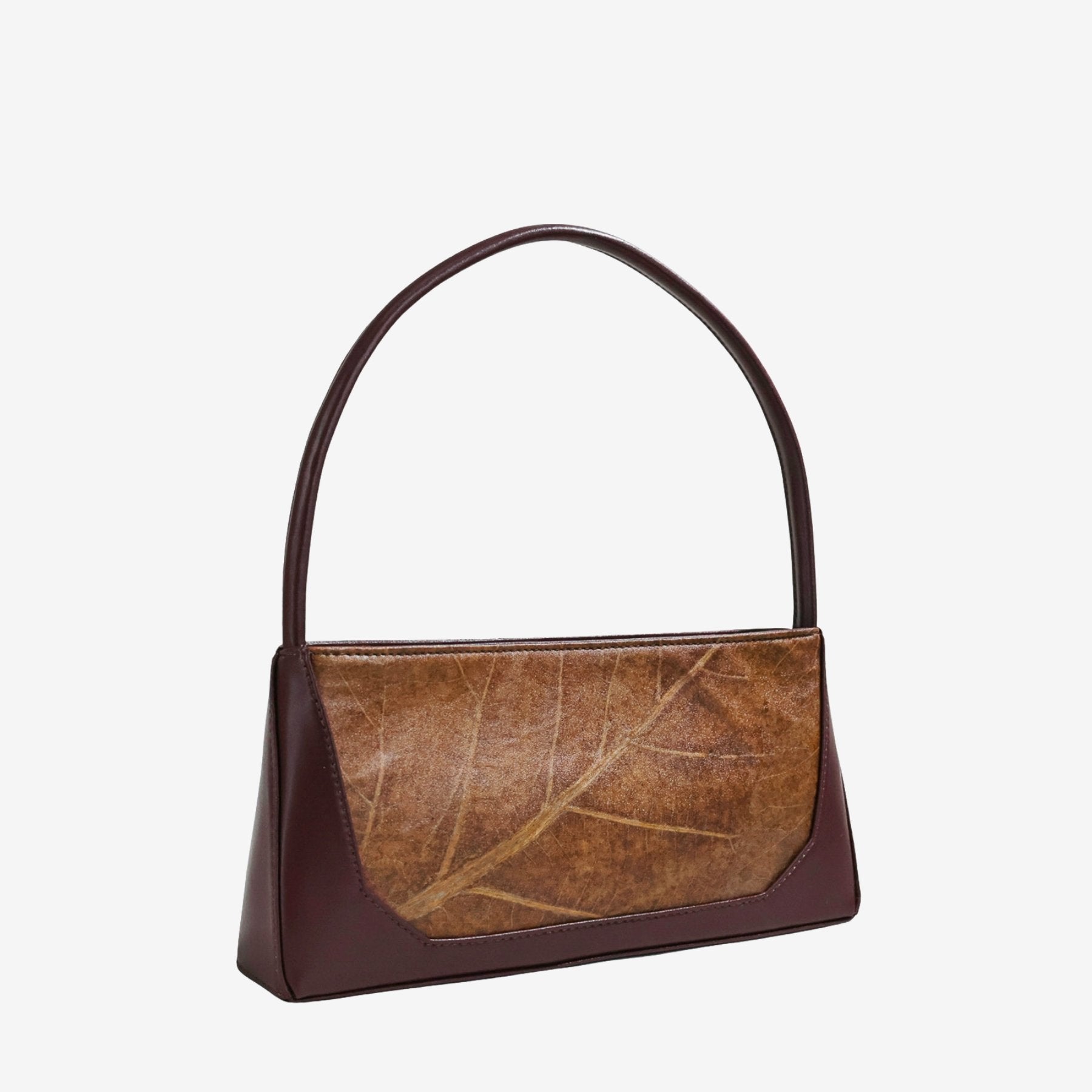 Three-quarter angle of IVES bag in spice brown leaf leather highlighting its practical shape