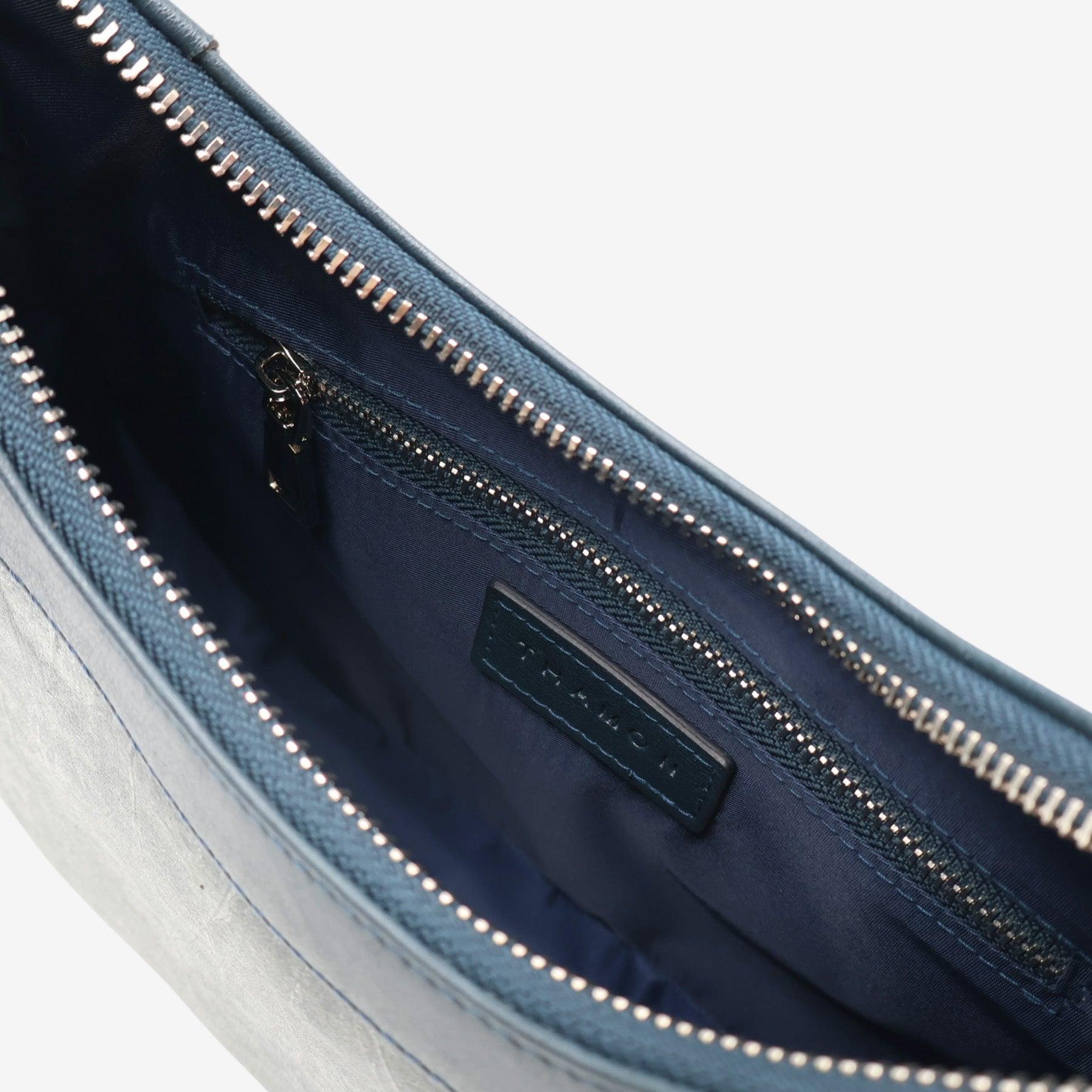 Interior of Kara Vegan Shoulder Bag in Blue Dianne by Thamon highlighting the spacious compartment with a zip pocket and quality craftsmanship.