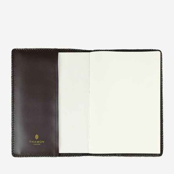 Open Lotus Leaf A5 refillable notebook with vegan leather cover and blank white pages, showing the Thamon London logo embossed in gold on the left side