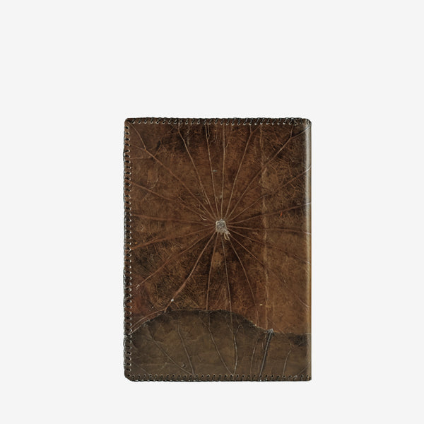 Back cover of a Thamon A5 refillable notebook made from lotus leaves in a weathered umber brown color with visible natural leaf patterns.