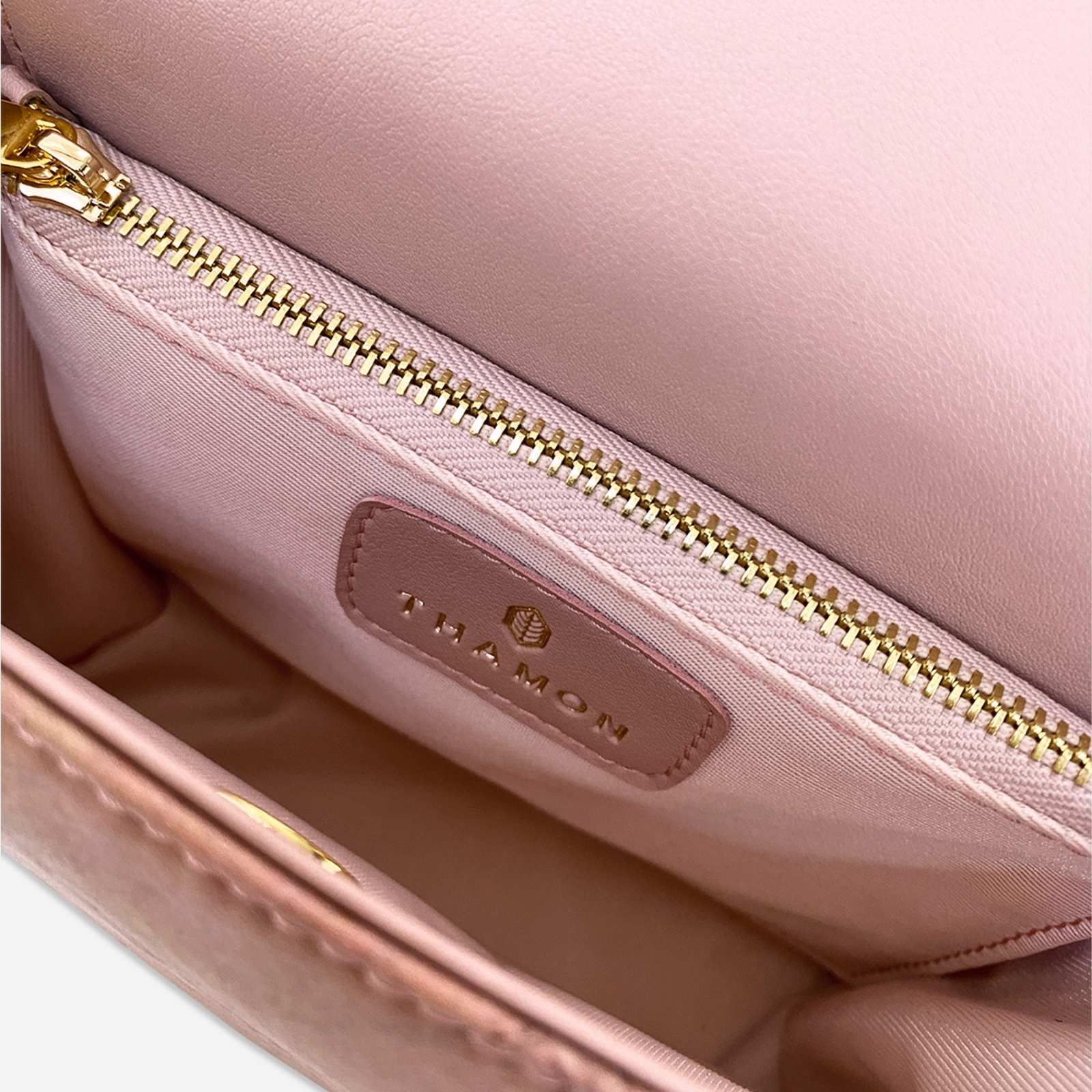 Interior zip pocket detail of the Pearl Crossbody Bag in Blossom Pink with gold-tone zipper