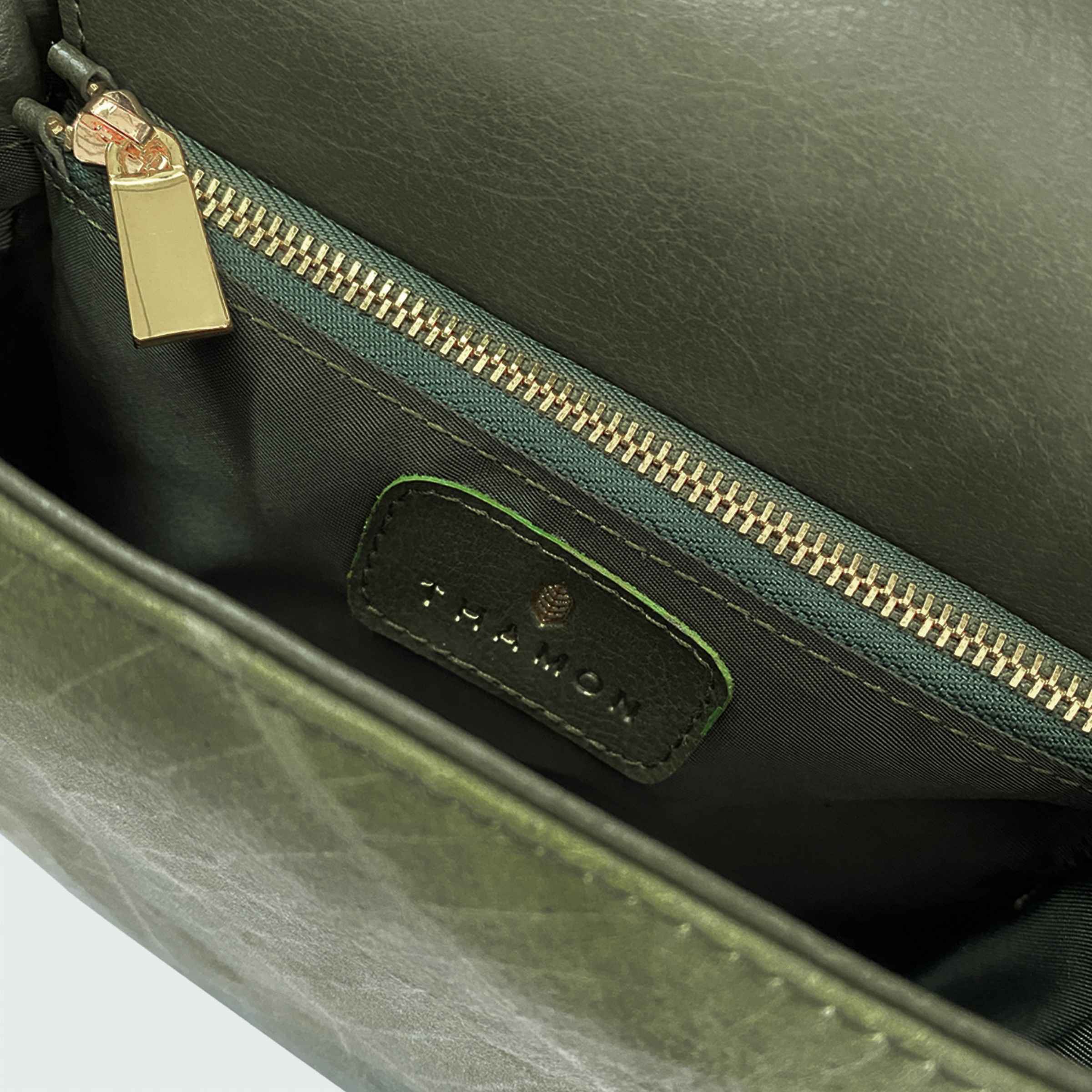 Interior view of Pearl bag in olive green showing embossed Thamon logo and lining