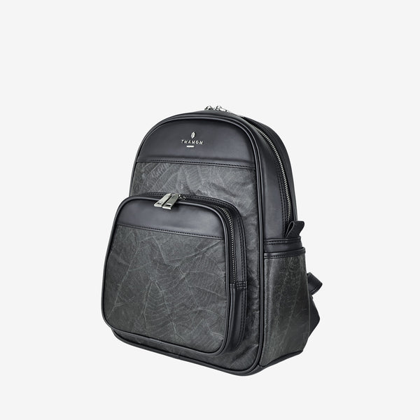 Side view of the Thamon Foglia backpack in black, made from sustainable leaf leather with a natural leaf texture, featuring a front zip pocket and silver-tone hardware.