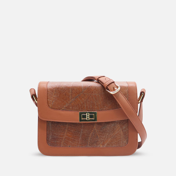 Front view of the Molly bag by Thamon, crafted from caramel brown vegan leaf leather. This eco-friendly women's handbag features a sleek rectangular shape with a flap closure and an adjustable shoulder strap. The natural leaf texture is visible on the leather surface, giving the bag a unique and sustainable design. Ideal for conscious fashion lovers.