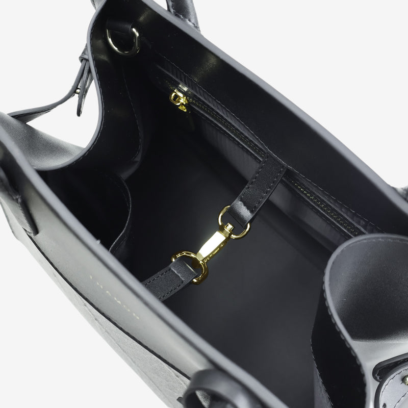 Interior view of the Sloane tote bag in black vegan leather, showing multiple compartments, a zippered pocket, and gold-tone hardware details, including a clasp for added functionality.