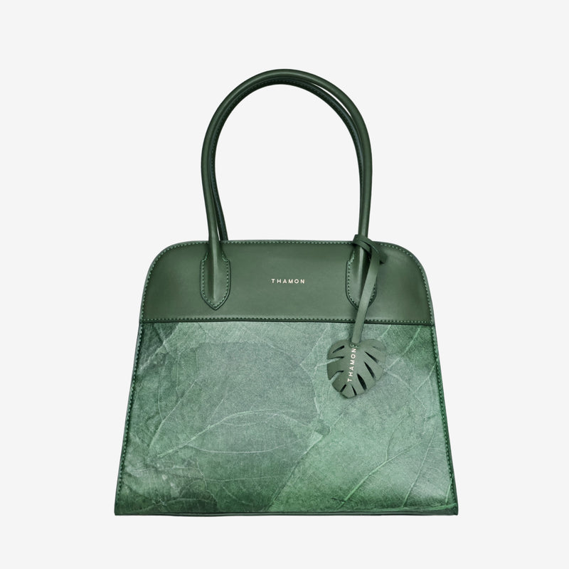 Sloane tote bag made from forest green vegan leather featuring a natural leaf pattern and top handles.