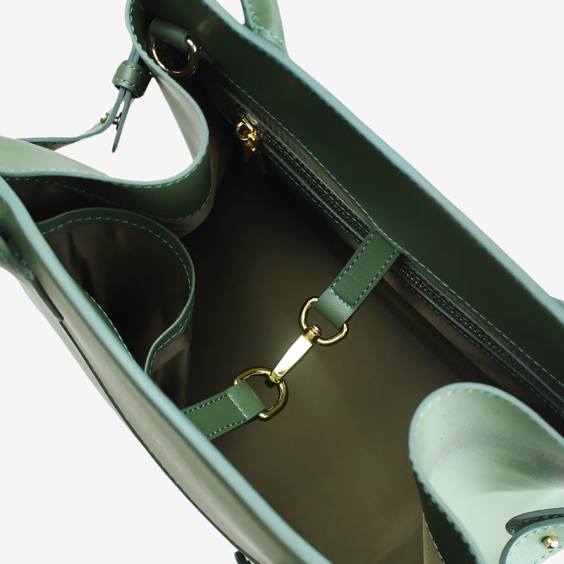 Interior view of the Sloane tote bag in forest green vegan leather, showing multiple compartments, a zippered pocket, and gold-tone hardware details, including a clasp for added functionality.