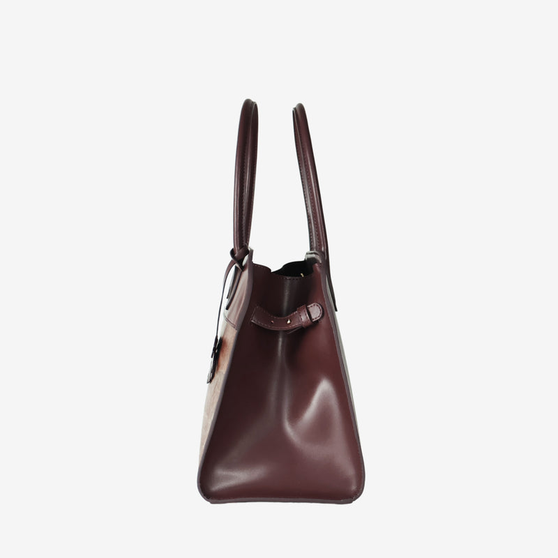 Side profile of the Sloane tote bag in spice brown vegan leather, featuring a smooth, structured surface, sturdy top handles, and a minimal design.