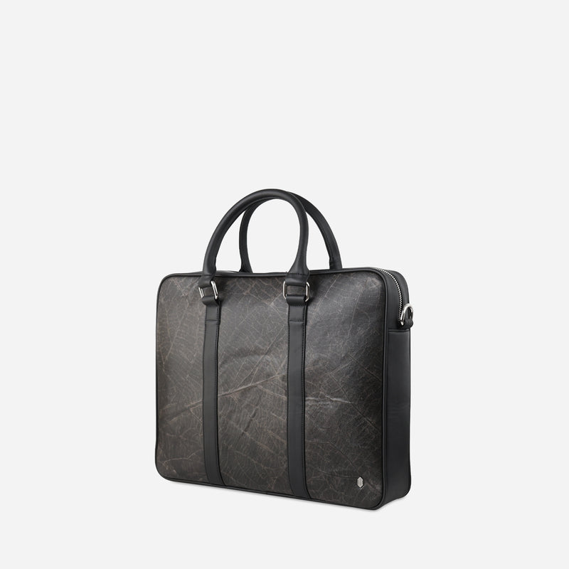 A side viewed of the Black Cambridge briefcase by Thamon crafted from black leaf leather with a natural leaf vein pattern and rounded handles.