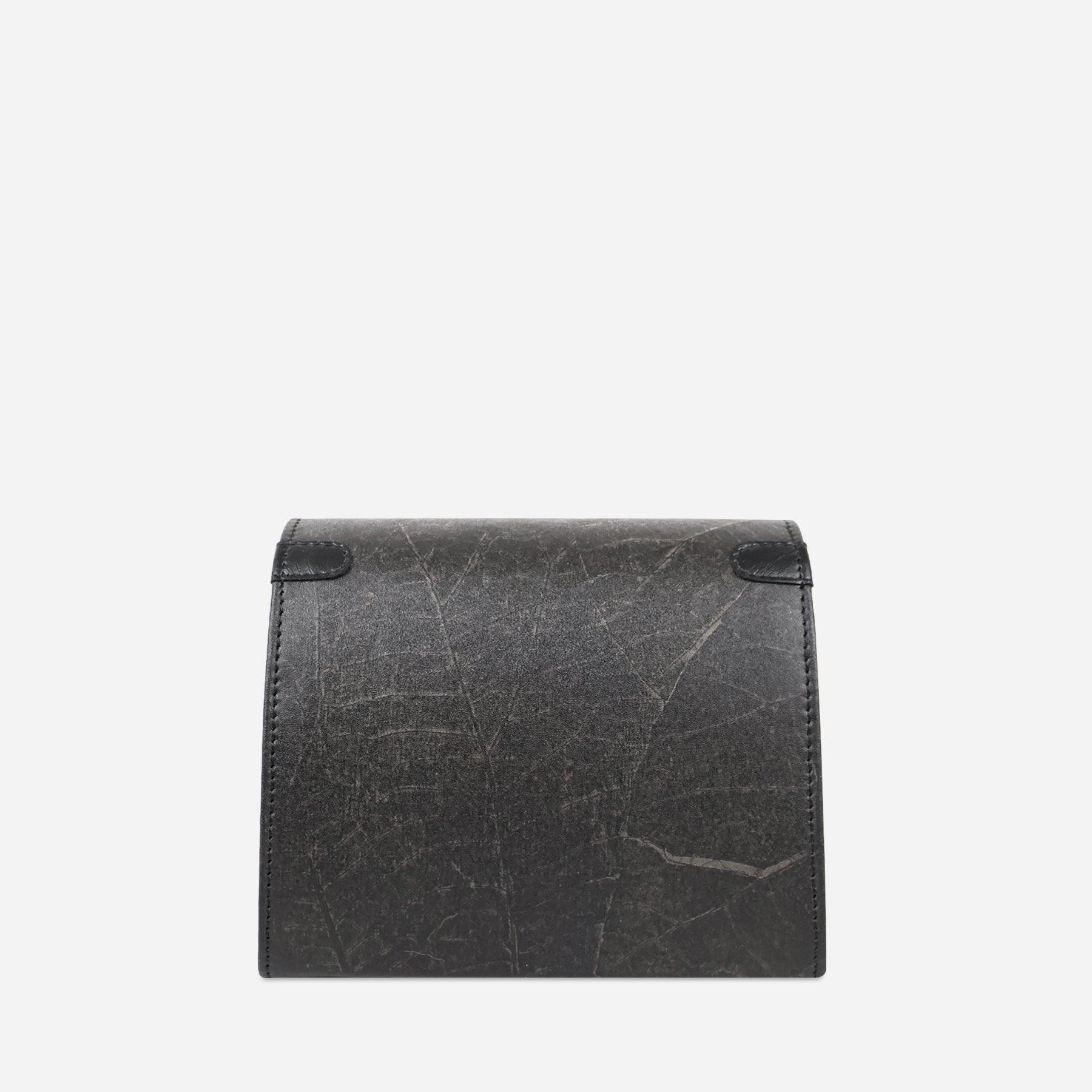 Back view of the Thamon London black leaf leather box bag, displaying its continuous leaf-patterned texture and meticulous stitching, with a clean, seamless design and no additional hardware, against a neutral background.