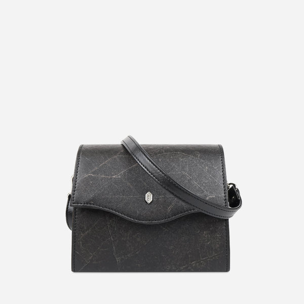 Front view of the Box Vegan Crossbody Bag in Black Leaf, showcasing its unique leaf leather texture and elegant black color, complemented by a sleek, detachable strap and Thamon branded hardware detail.