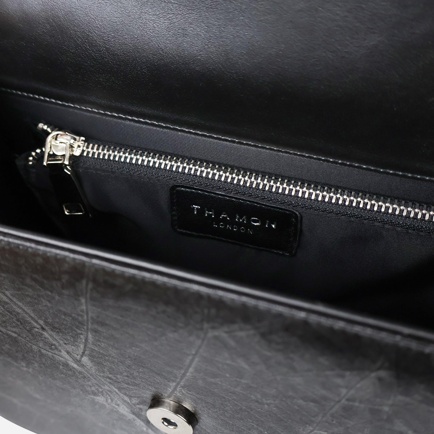 Interior view of black Camden crossbody bag showing zip pocket and Thamon leather logo label