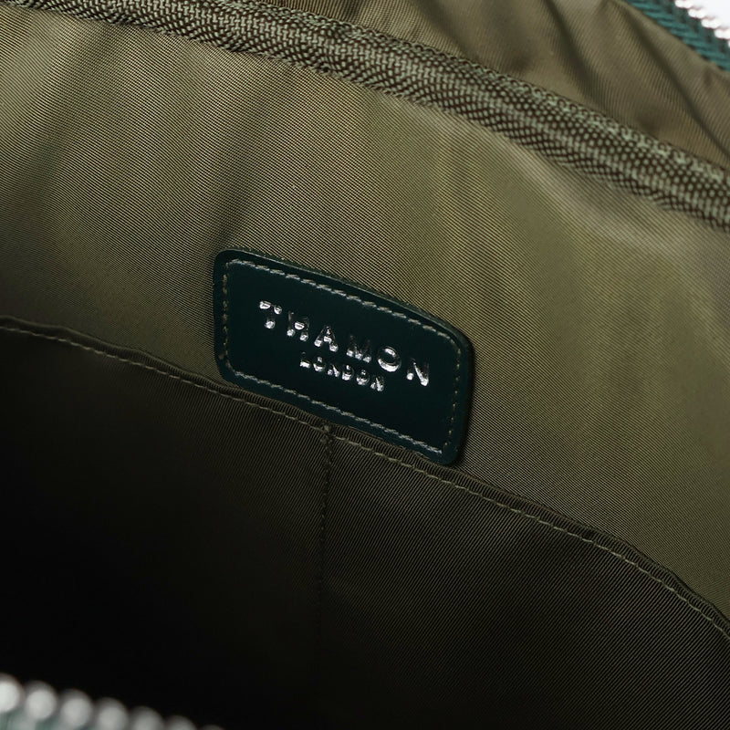 Interior view of a Thamon forest green leaf leather Cambridge briefcase, showing the khaki green lining with the brand's logo and two internal pockets.