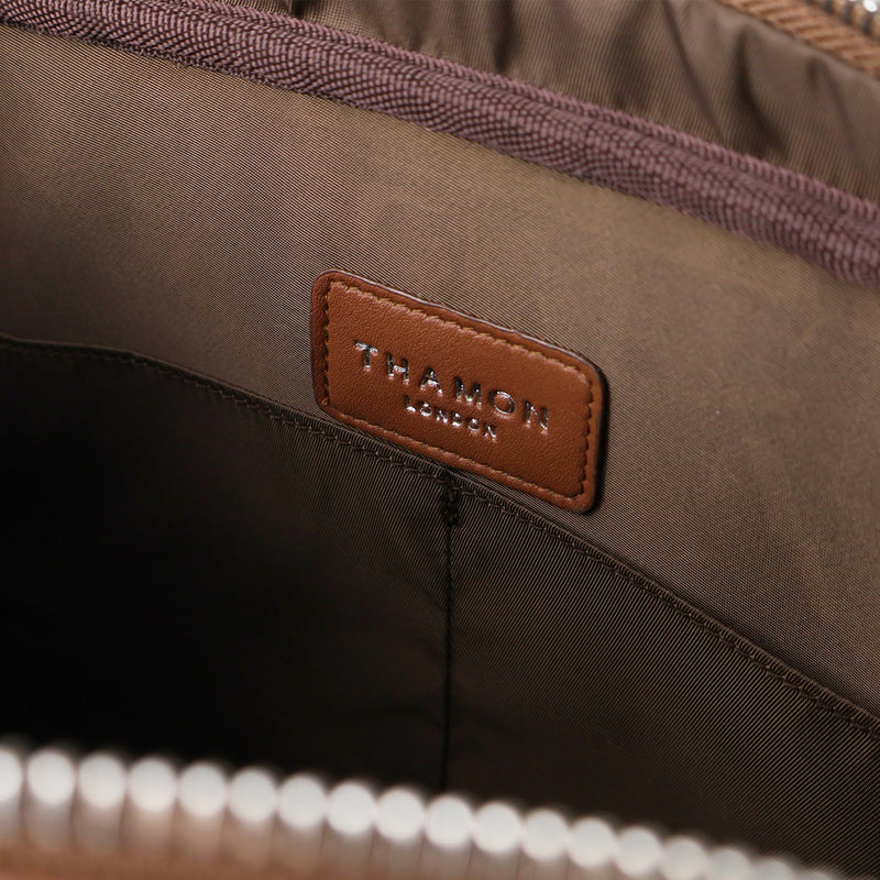 Interior view of a Thamon spice brown leaf leather Cambridge briefcase, showing the brown lining with the brand's logo and two internal pockets.