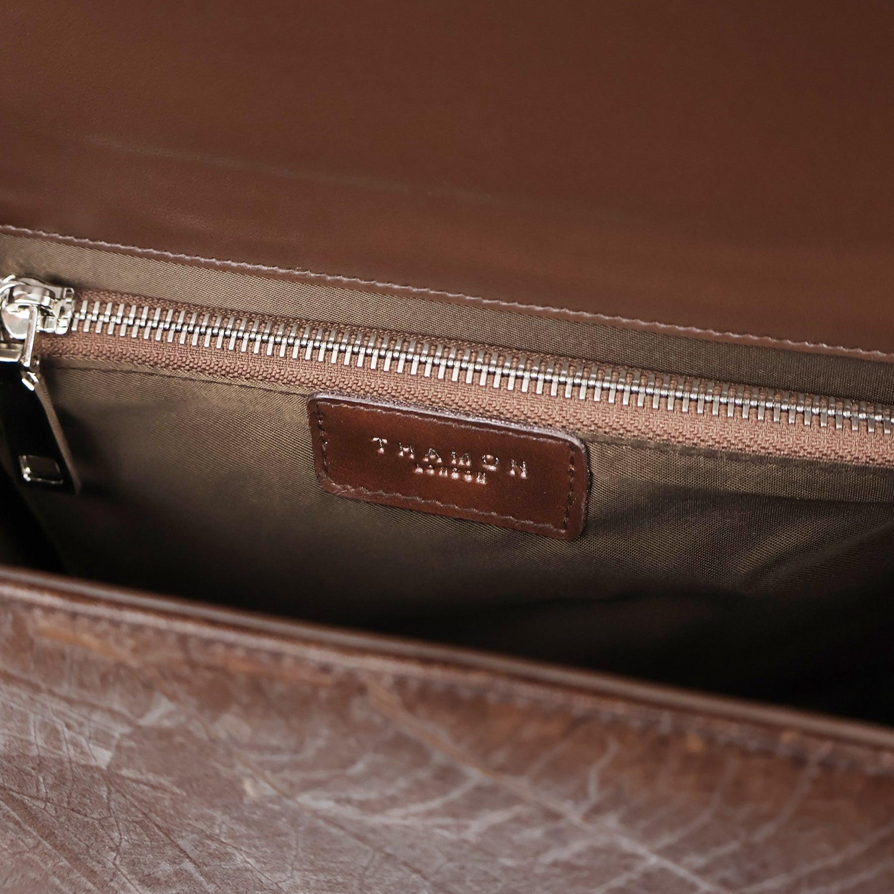 Interior view of Camden crossbody bag in walnut brown Leaftex, showing zip pocket with Thamon leather logo label