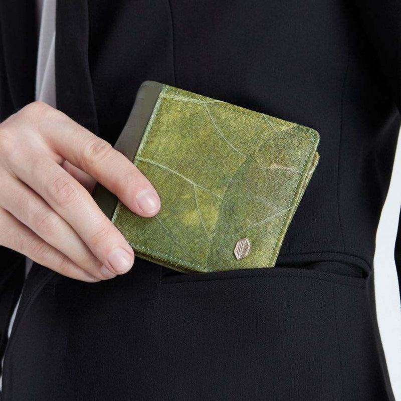 Front view of the Olive Vegan Leather Men's Coin Wallet by Thamon held by a man wearing a black jacket, highlighting its compact design